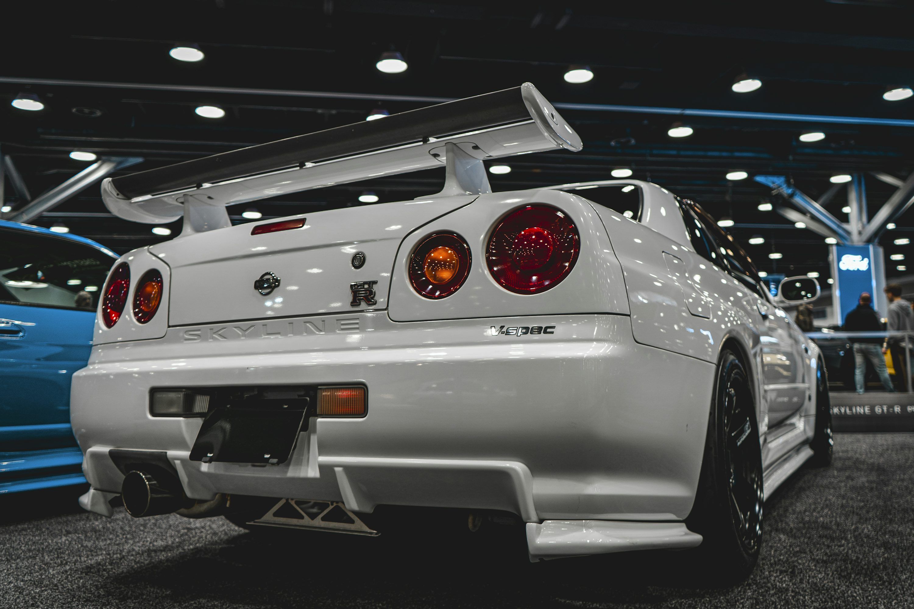 3000x2000 A white car parked in a showroom next to a blue car photo
