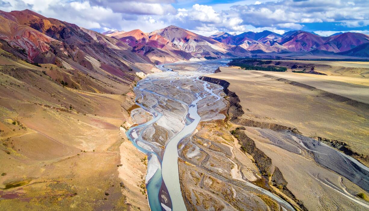 1225x700 Top down alluvial fan channels fanning gently soft mineral palette wallpaper background representing geomorphic pattern suitable for geology and mapping design
