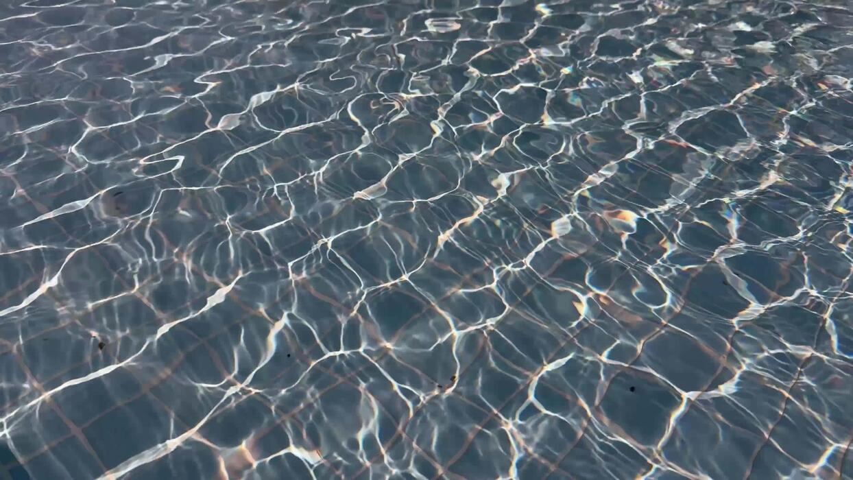 1244x700 Sunlight reflecting on water surface in swimming pool with visible tile pattern. Abstract background texture. Summer vacation and relaxation concept. Design for wallpaper, banner, poster, header
