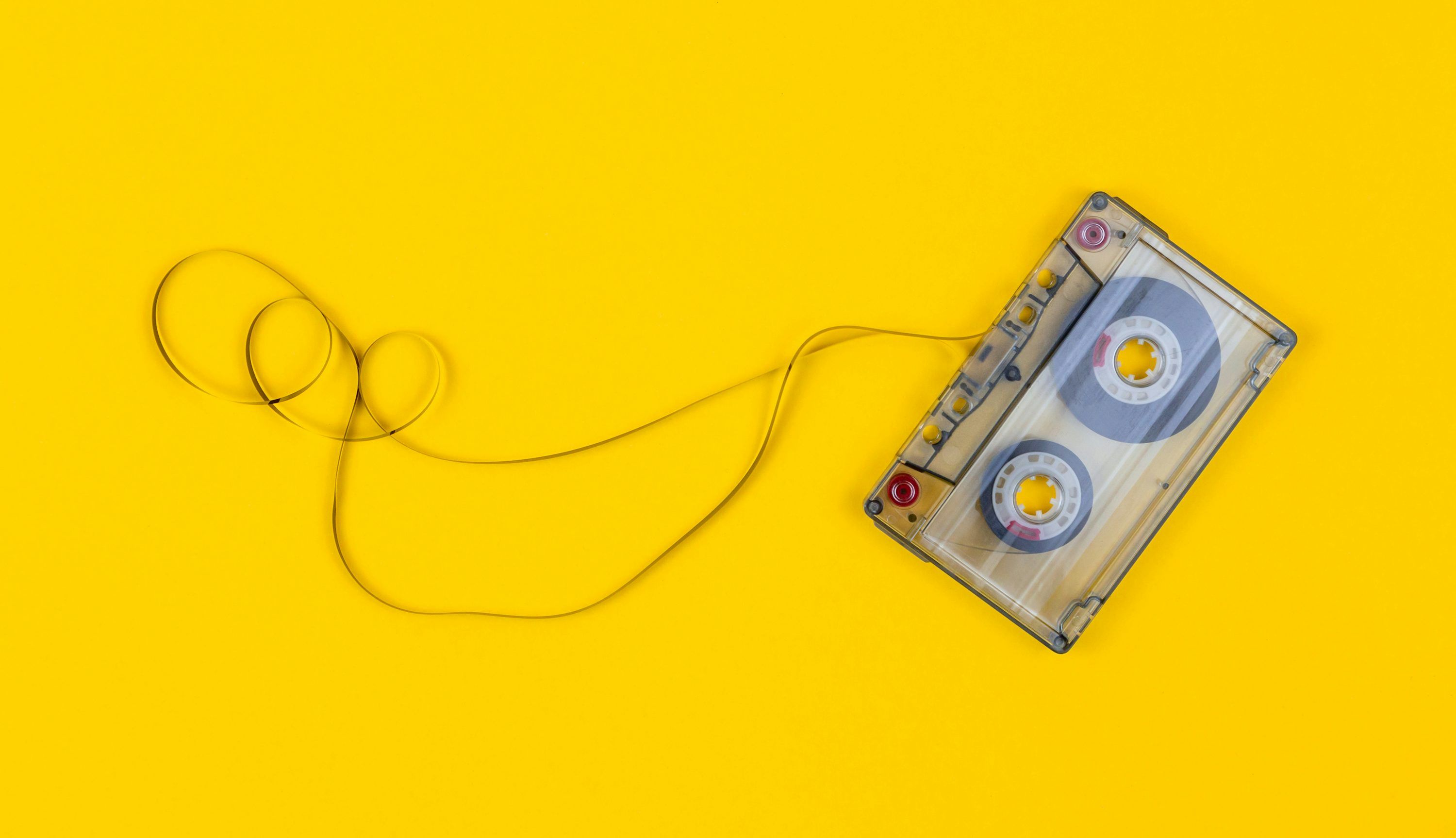 3000x1726 Gray cassette tape on yellow surface photo