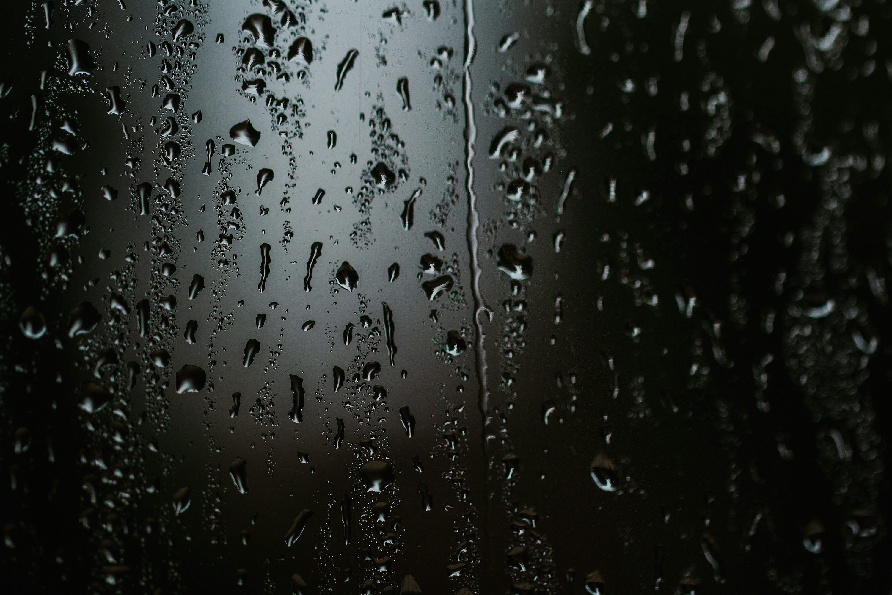 3000x2000 Rain drops on a window with a black background photo