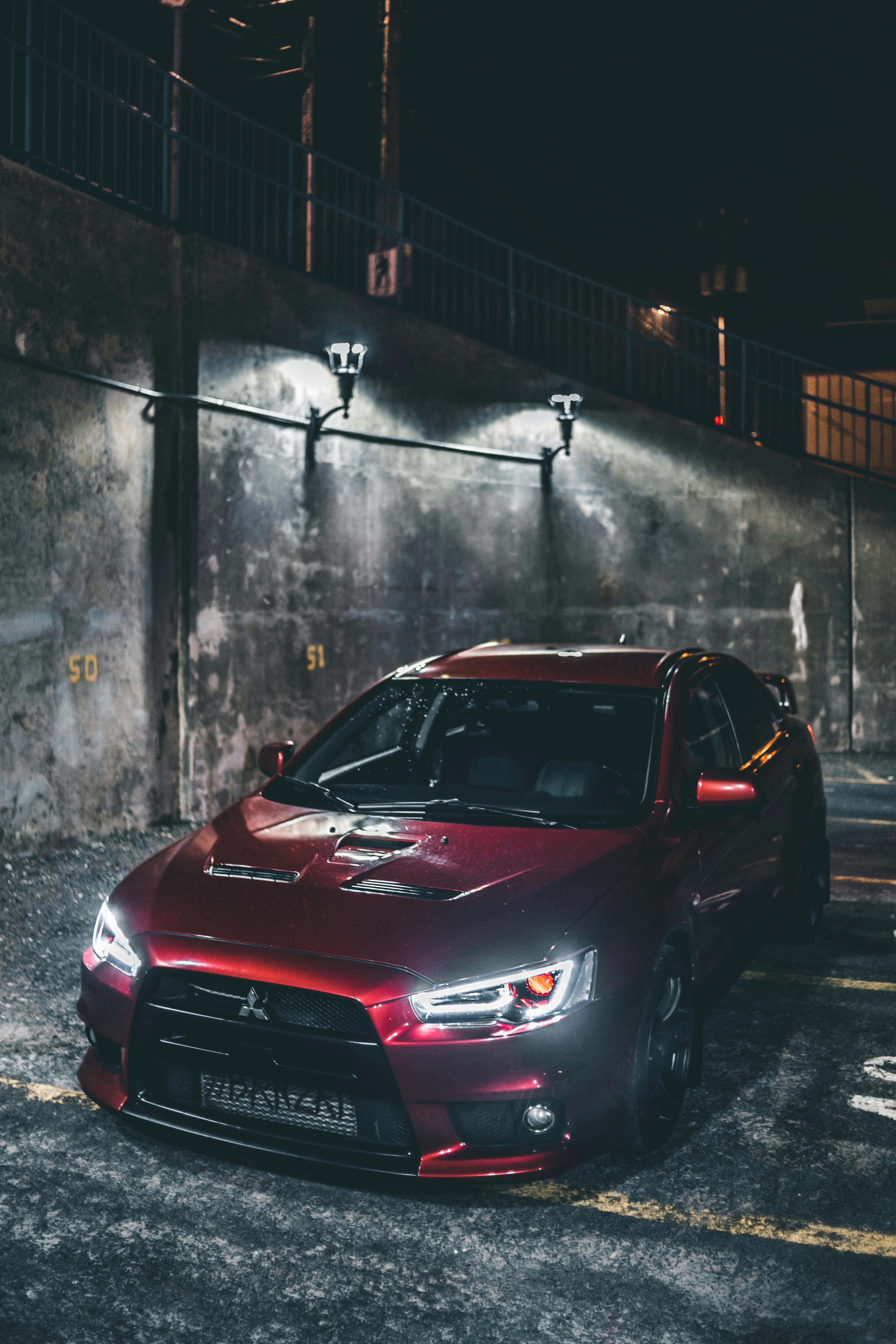3546x5319 A Red Mitsubishi Lancer Evo in a Parking Area · Free