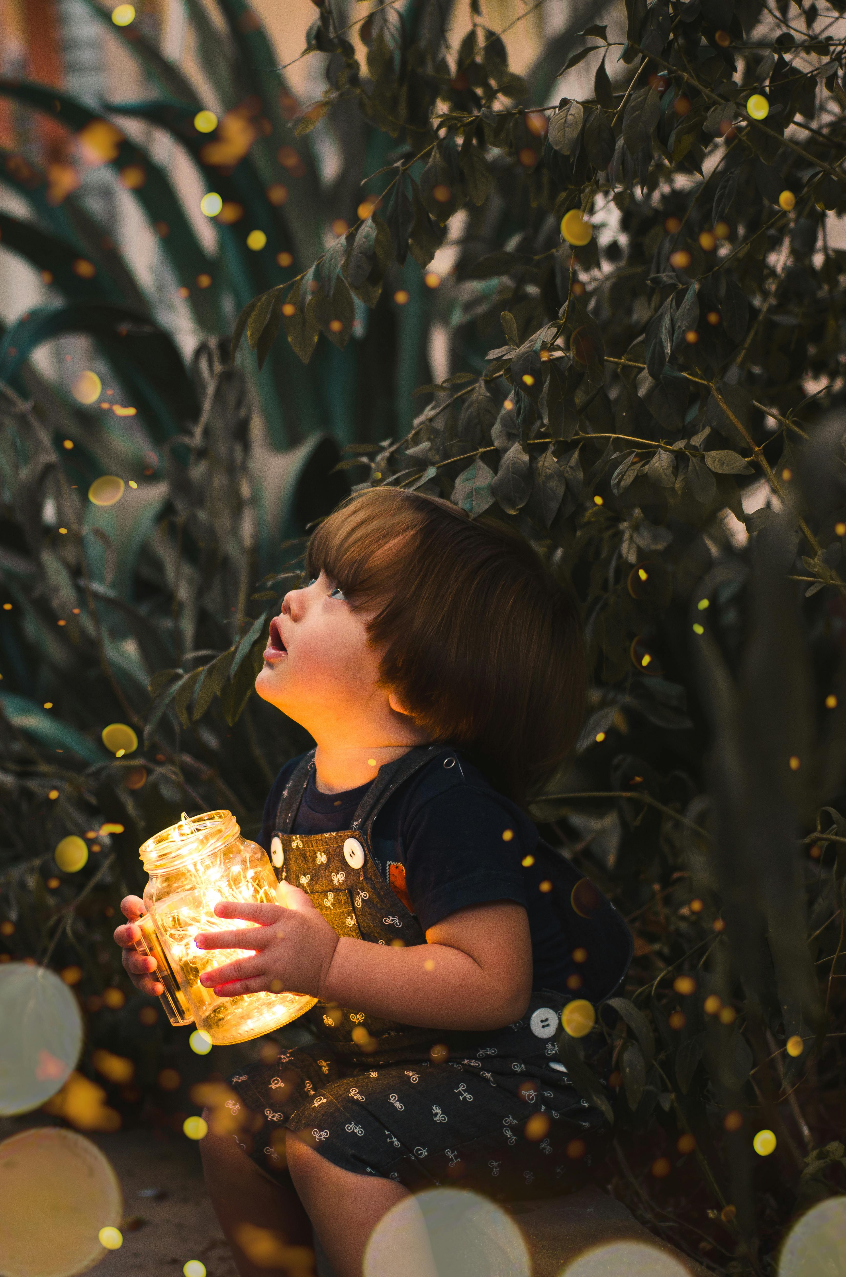 3312x5000 Child Holding Clear Glass Jar With Yellow Light · Free