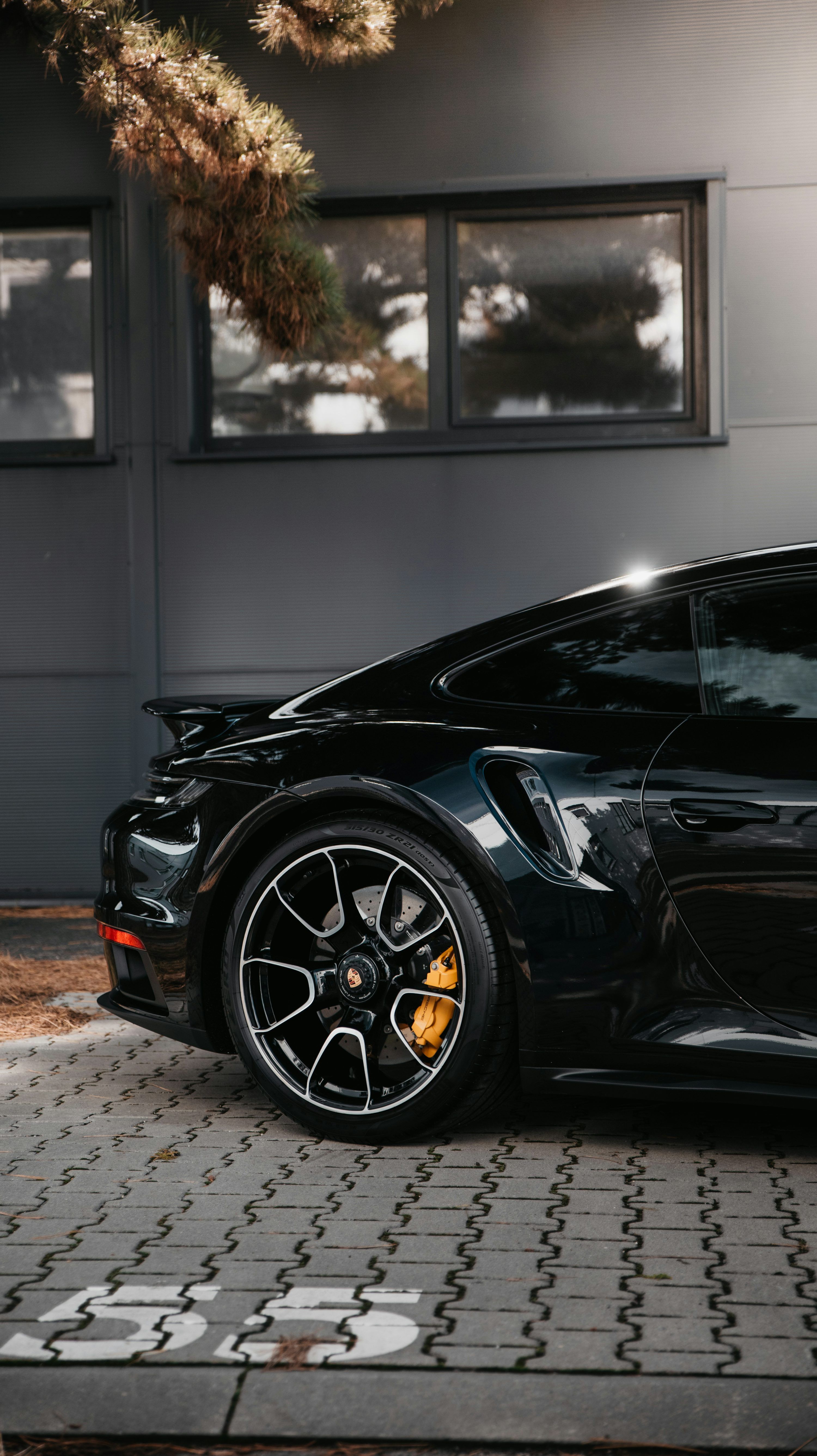 3000x5343 Black porsche 911 parked on gray pavement photo