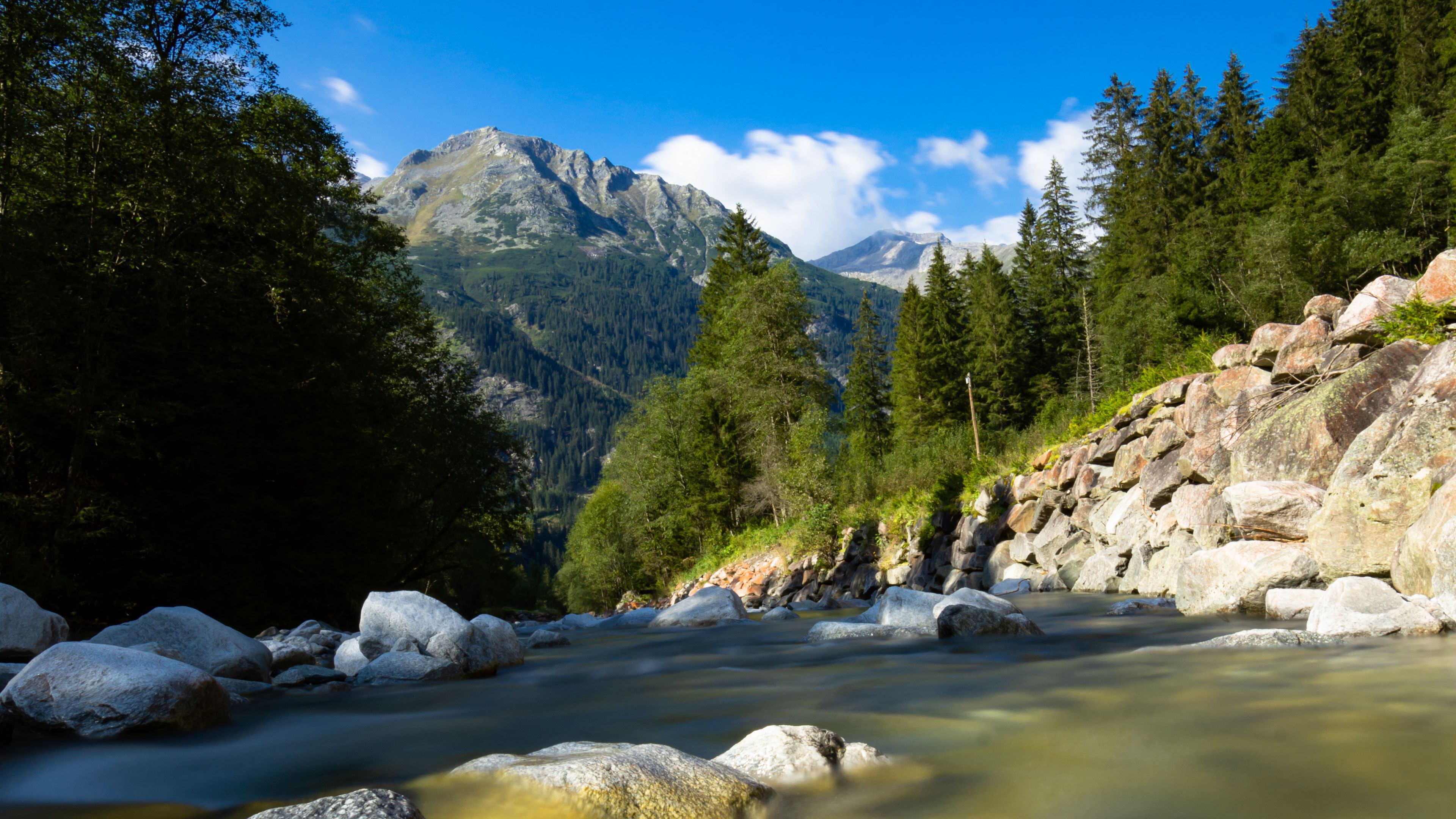3840x2160 Landscape View Of Top Hill Mountain Under Blue Sky And Stone On River 4K HD Nature Wallpaper