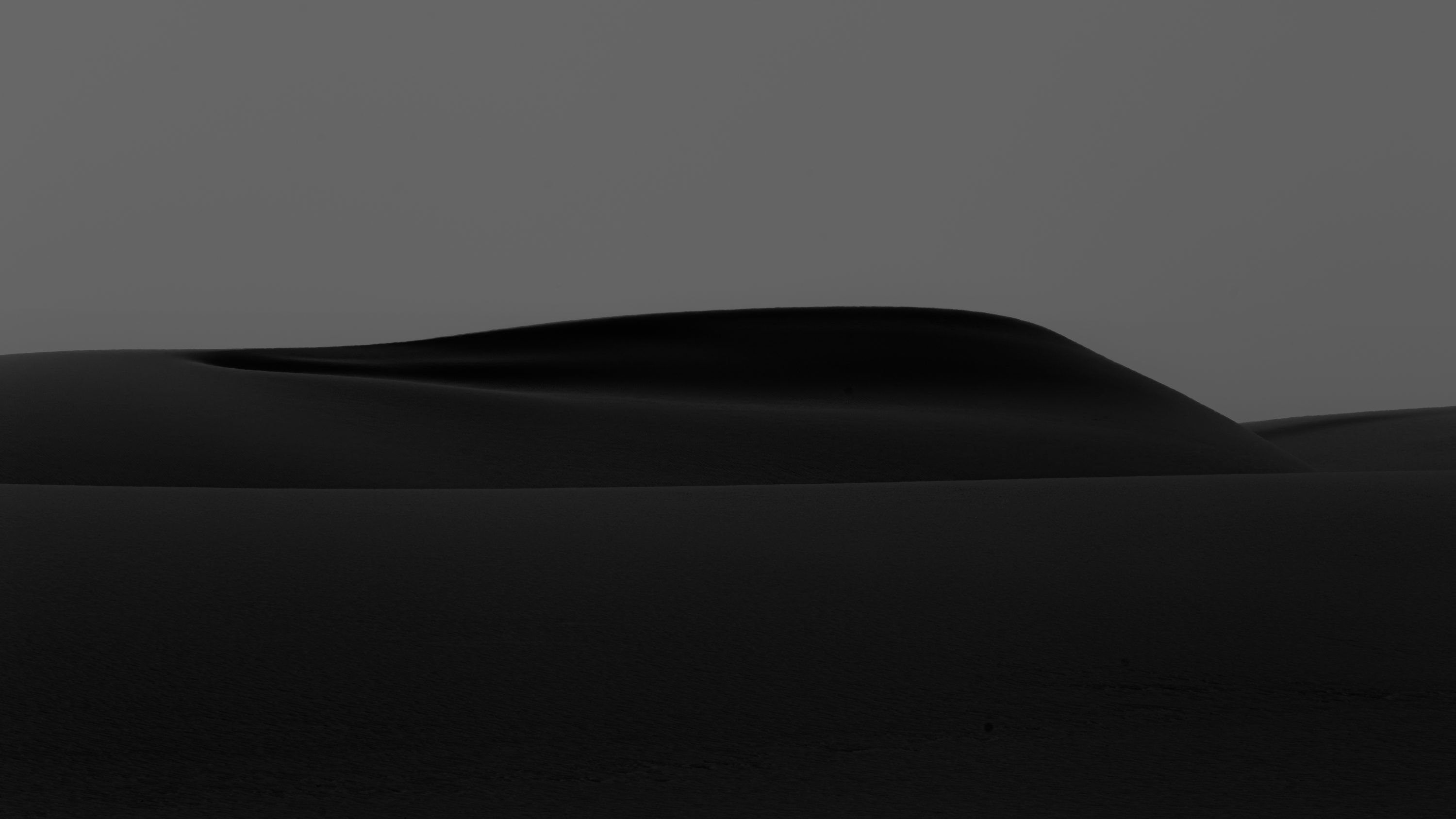 3000x1688 A large flat area with a hill in the background photo