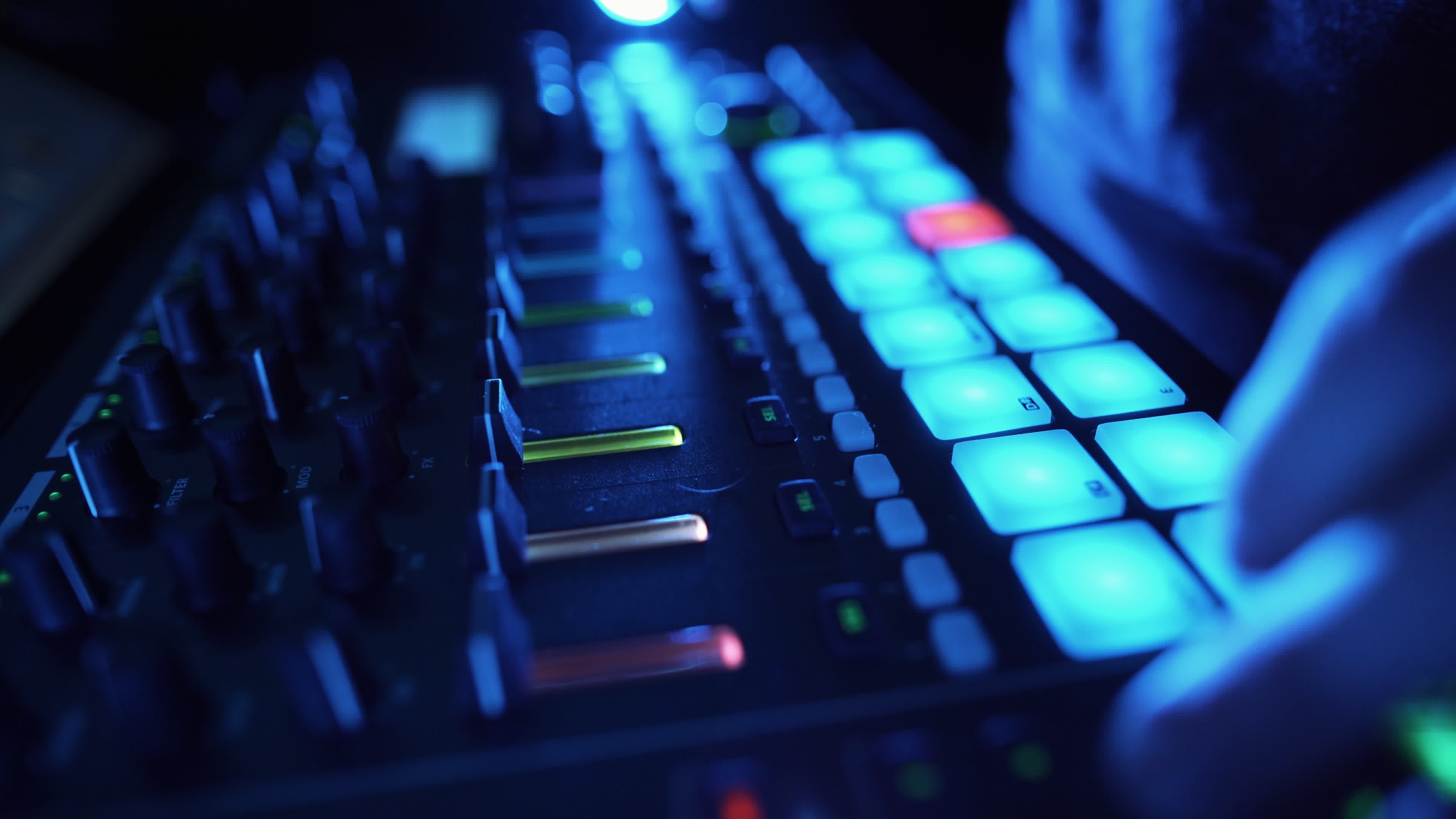 3840x2160 Professional DJ Plays a Beat Sampler with Color Drum Pads and Samples in Studio Environment. Beatmaker Plays edm Tracks on Party in a Nightclub. Electronic Musical Instrument. Unrecognizable person