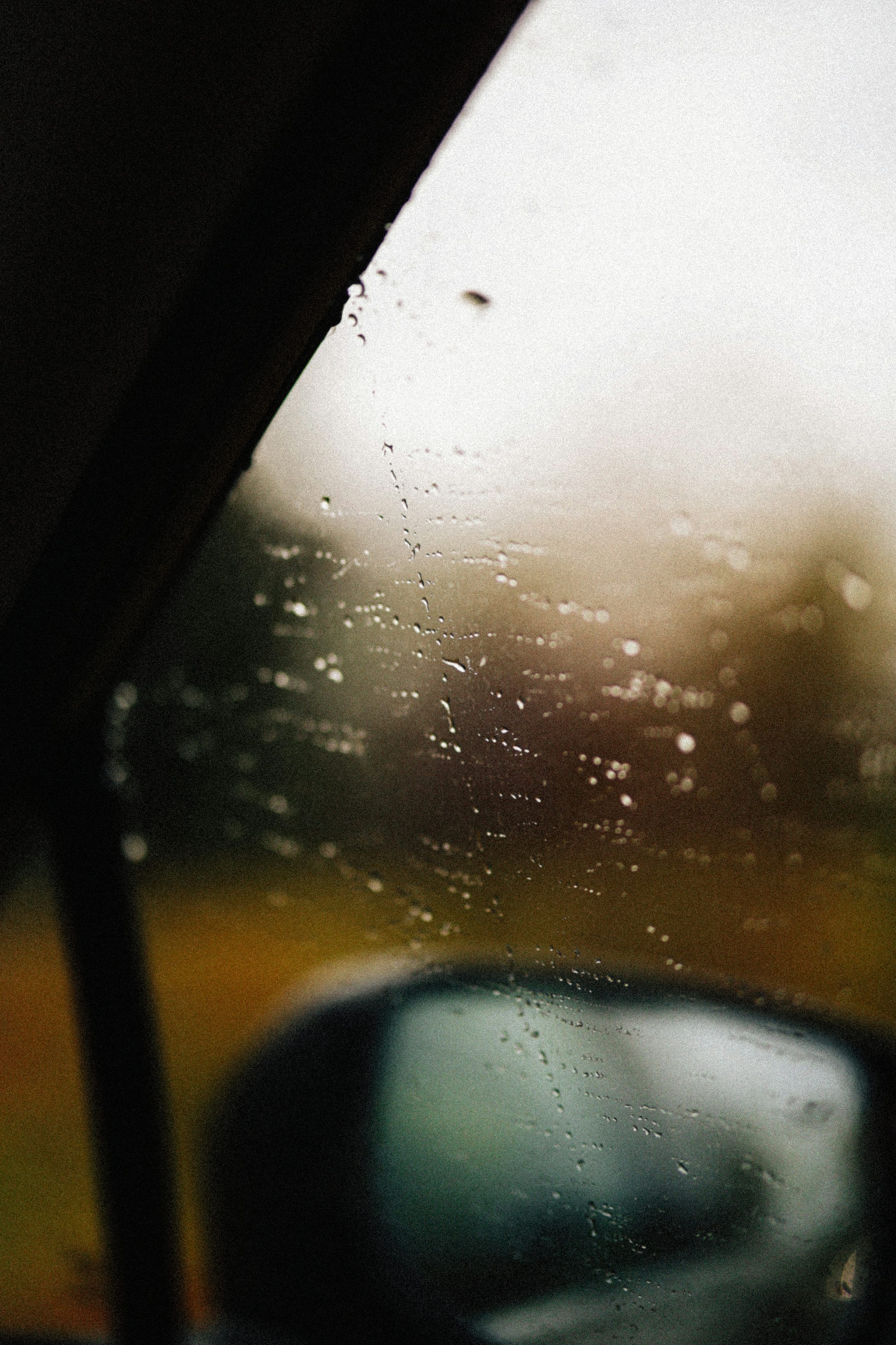 3000x4500 Raindrops streak a blurry car window. photo