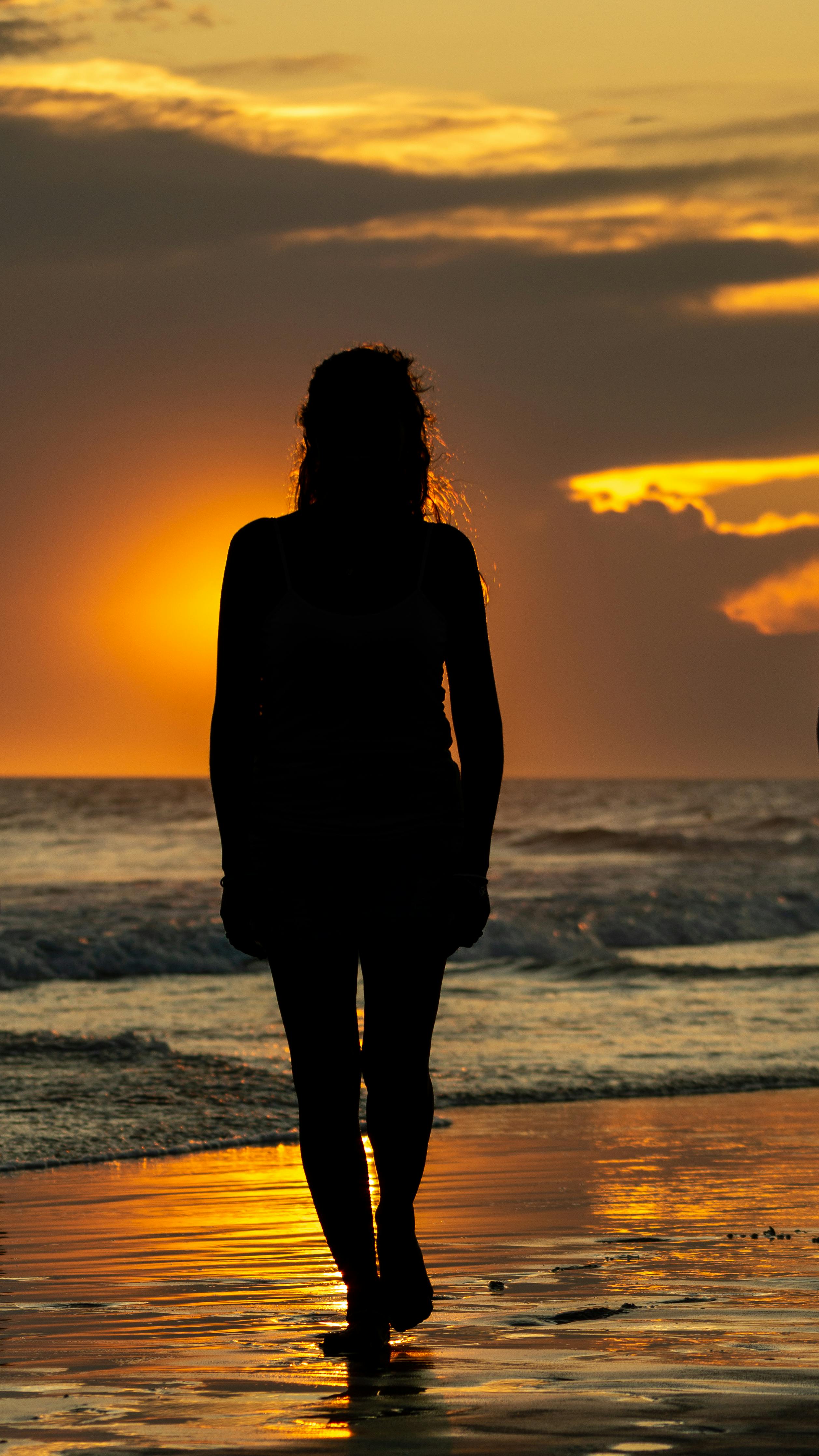 2516x4472 Silhouette of Woman Walking on Sea Shore at Sunset · Free