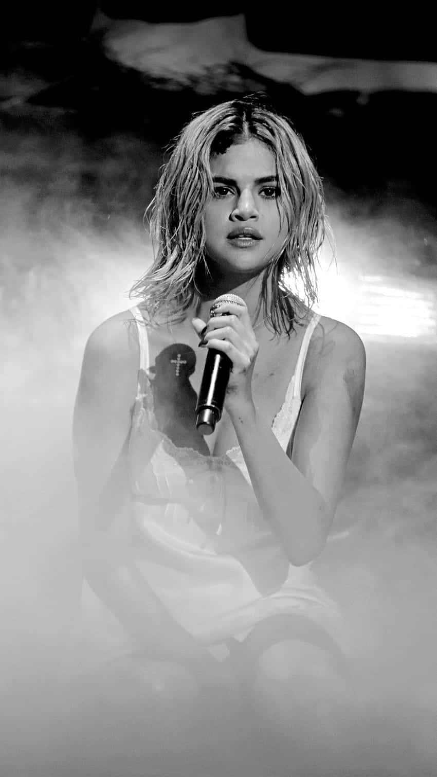 850x1511 Download Holding her iPhone X in her Hand, Selena Gomez is a Smartphone Icon Wallpaper