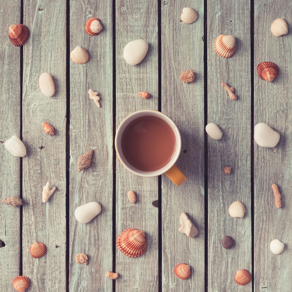 1000x1000 Summer morning coffee surrounded by pattern made of sea shells and rocks Photo (42eMK5)