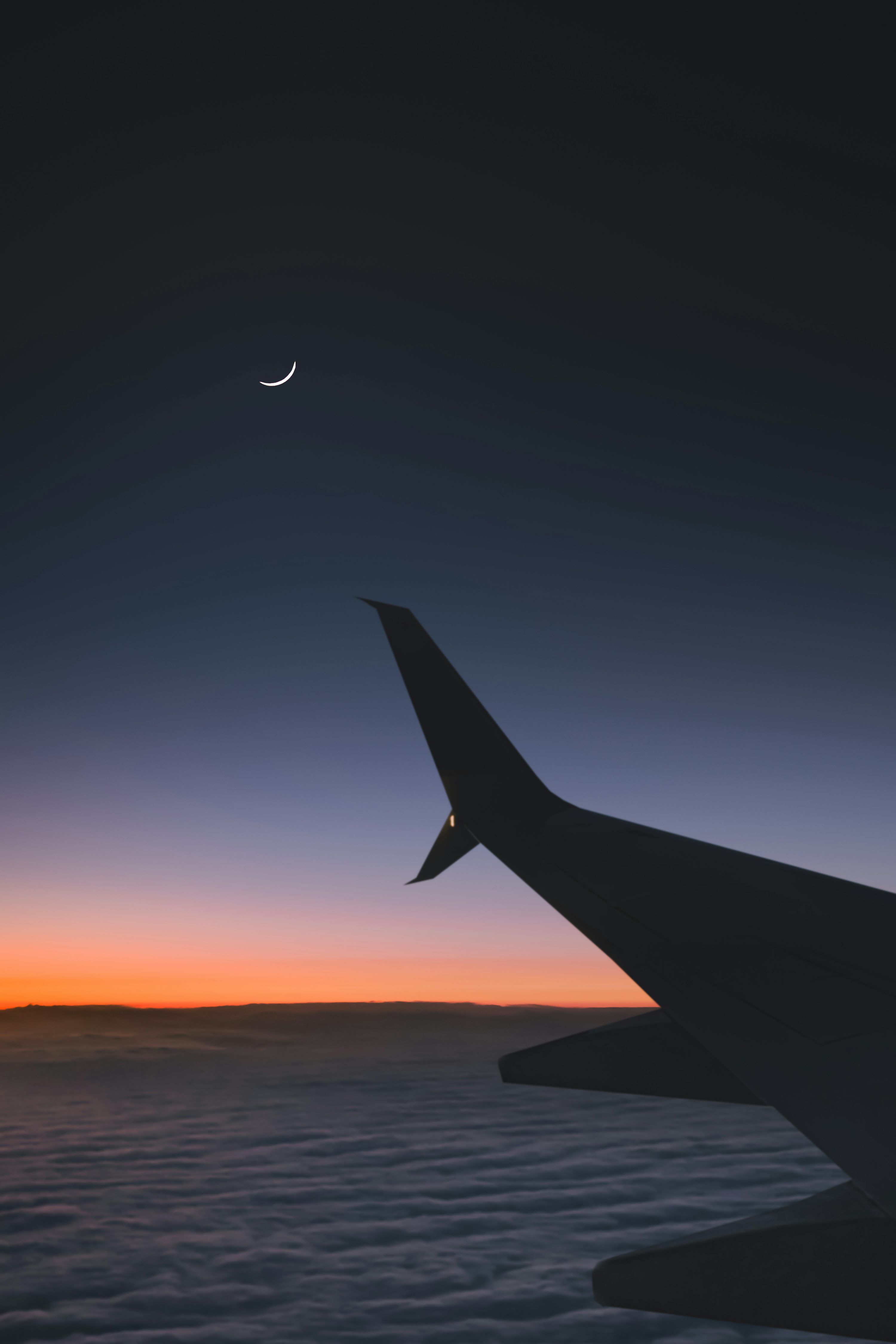 3000x4497 Airplane flying over the clouds during sunset photo