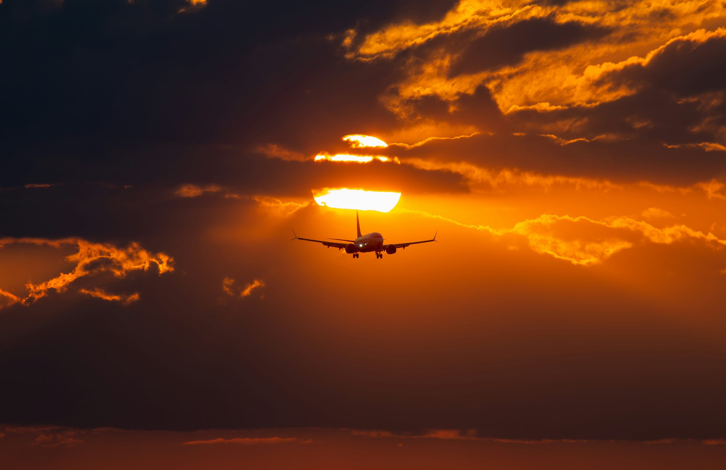 3000x1944 A plane flying in the sky at sunset photo