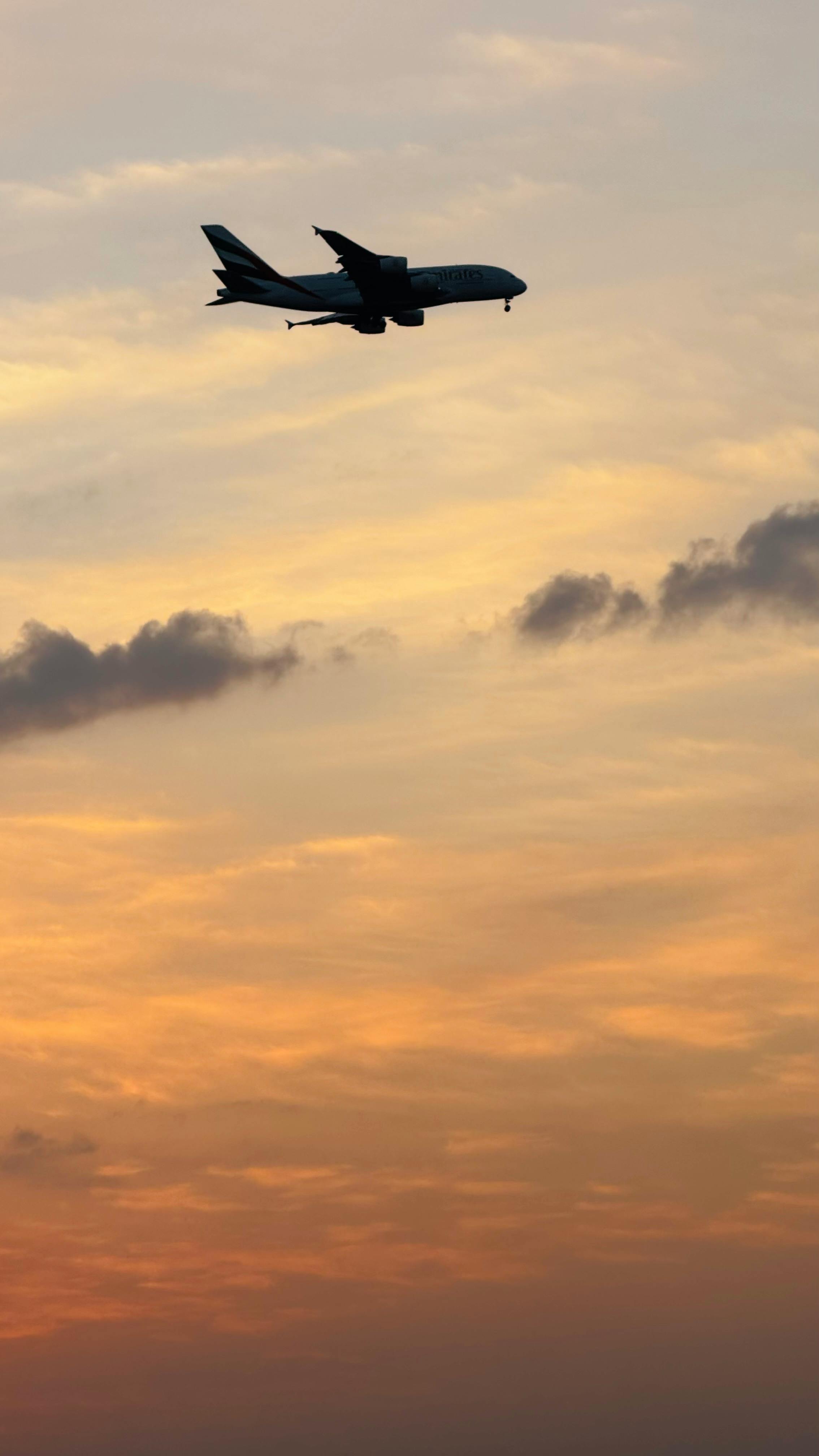 2268x4032 Airplane Silhouette Against Vibrant Sunset Sky · Free