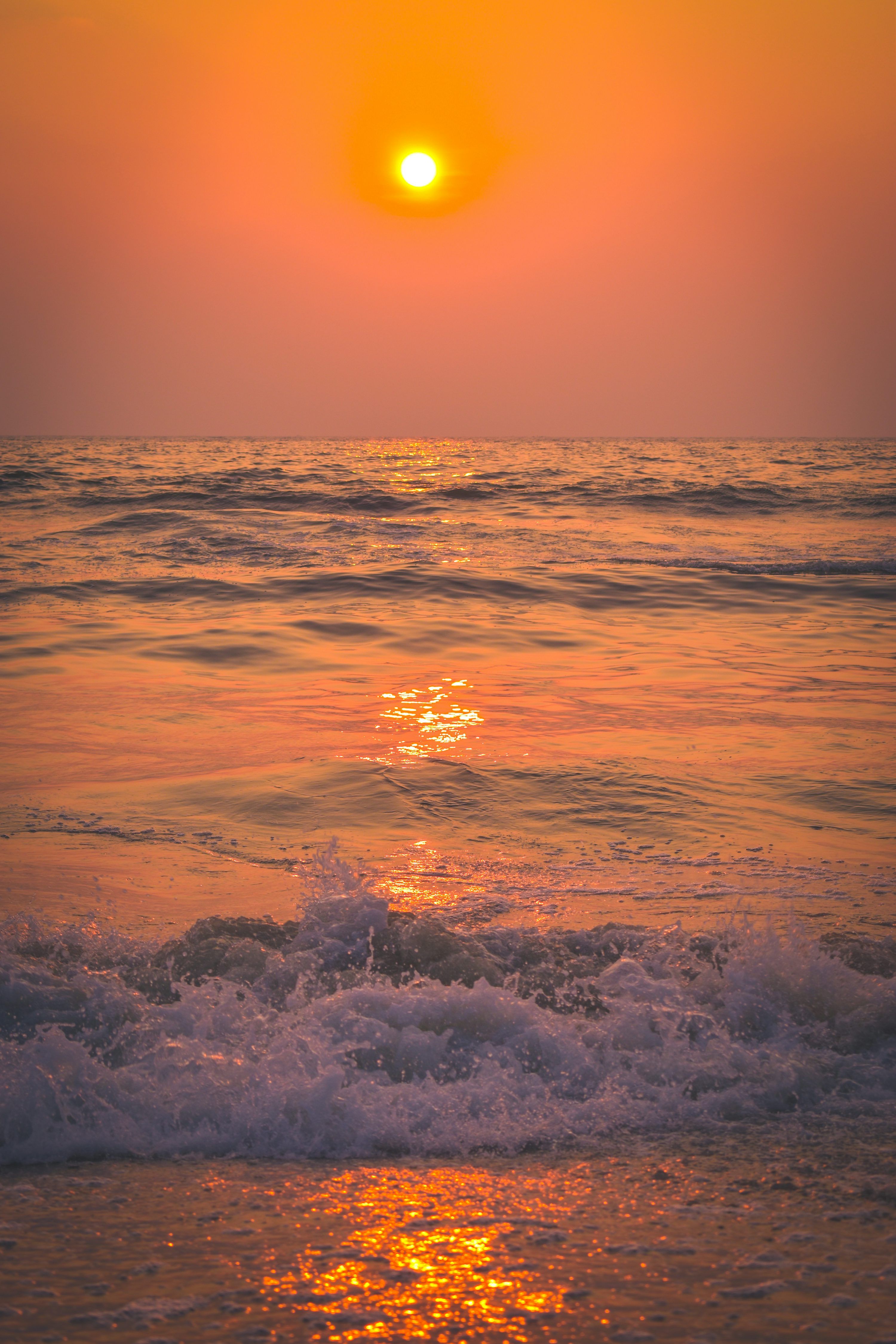 3000x4500 The sun is setting over the ocean waves photo