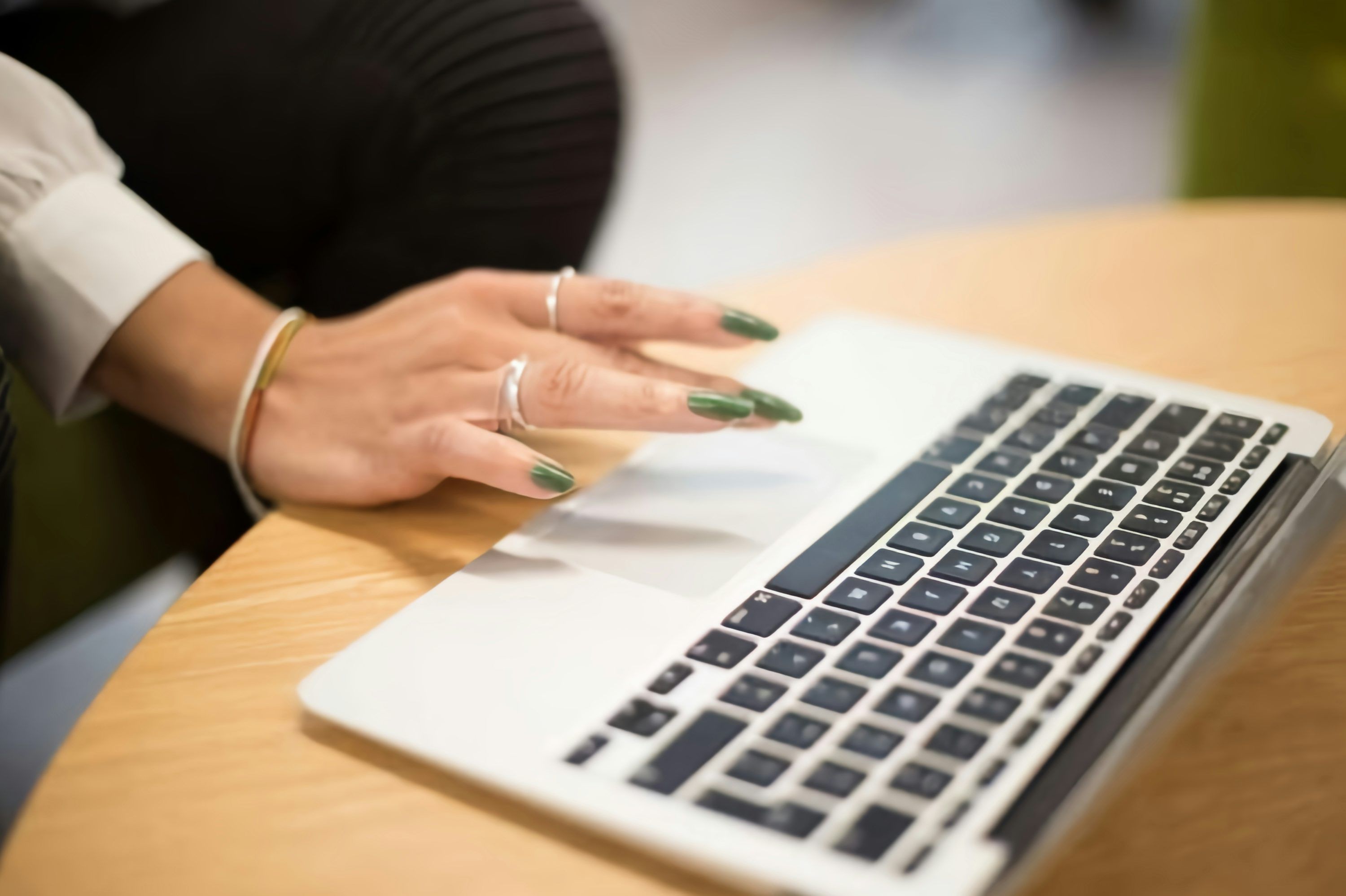 3000x1998 A woman sitting at a table using a laptop computer photo