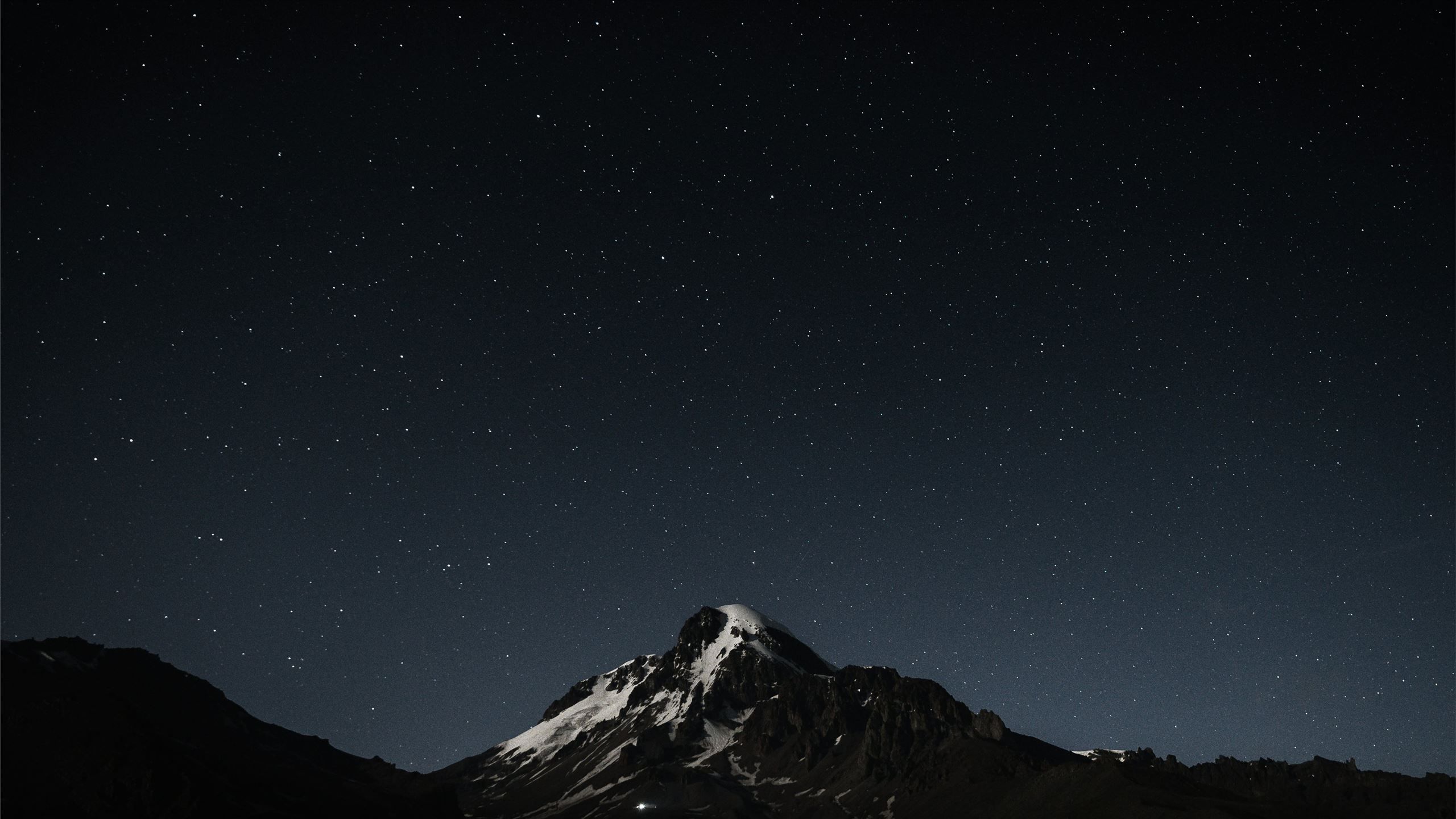 2560x1440 The night sky with stars above a mountain MacBook Air Wallpaper Download