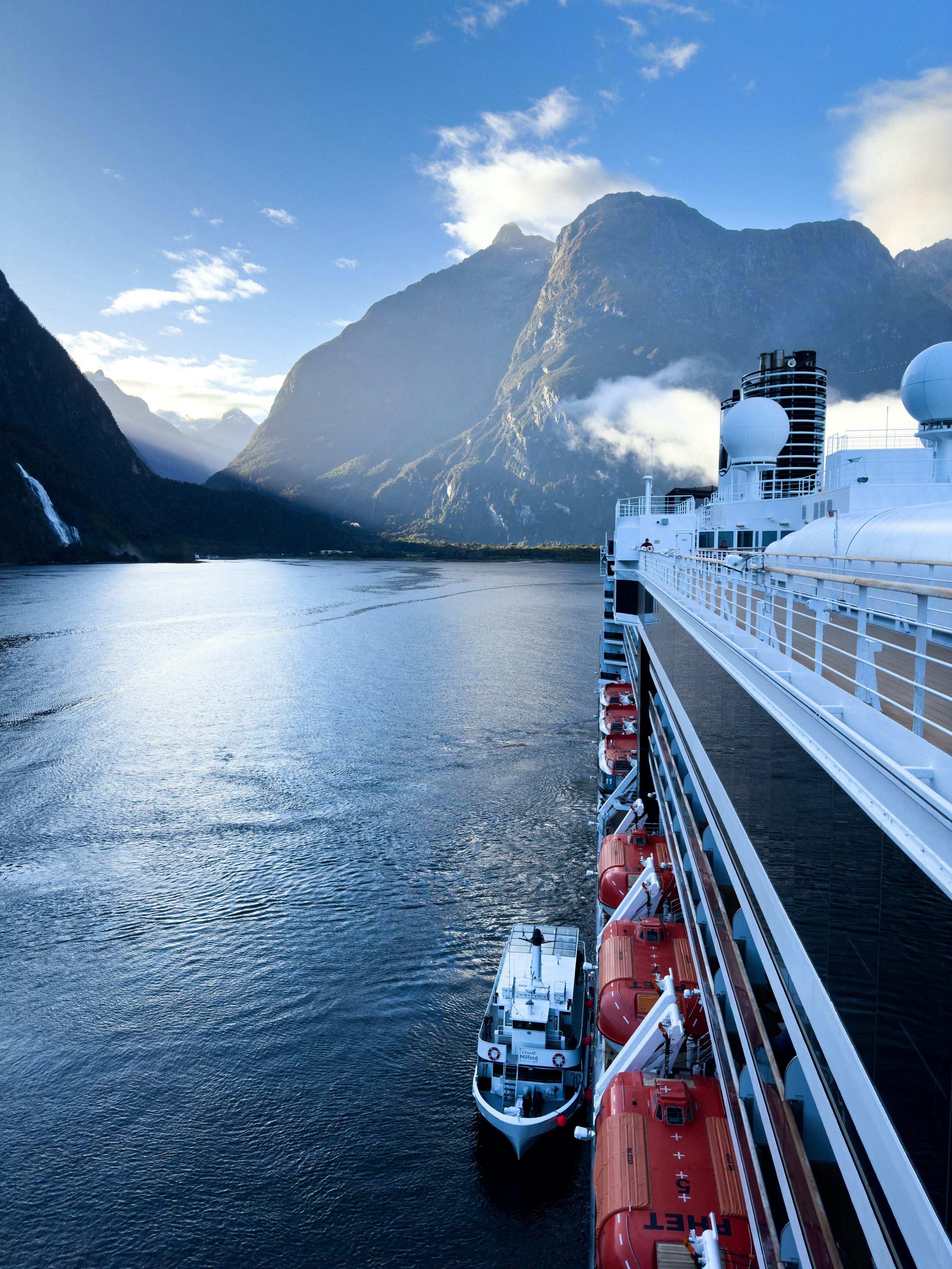 3000x4000 A cruise ship in a body of water with mountains in the background photo