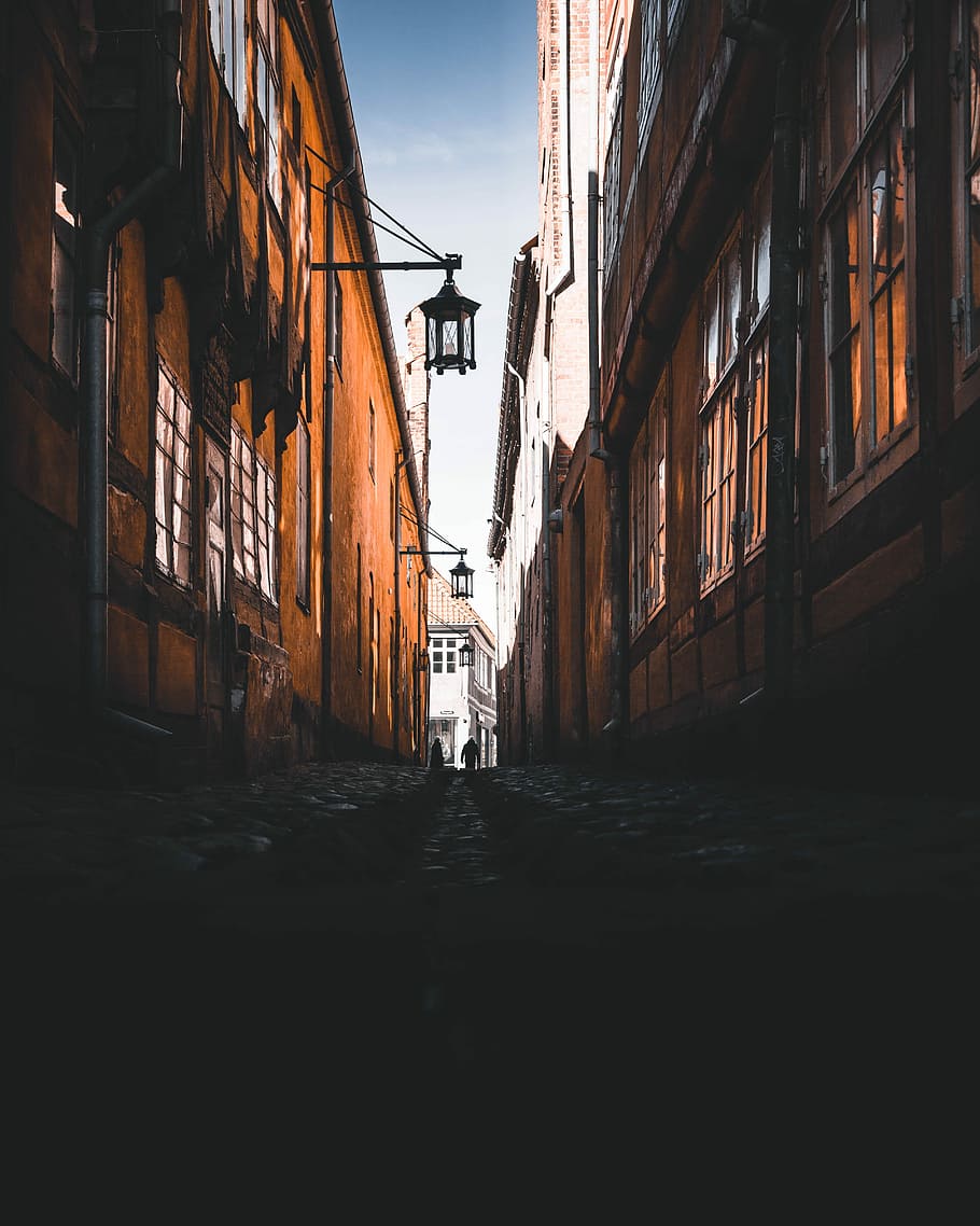 910x1138 HD wallpaper: two people walking on hallway between building, photo of pathway beside brown buildings during daytime