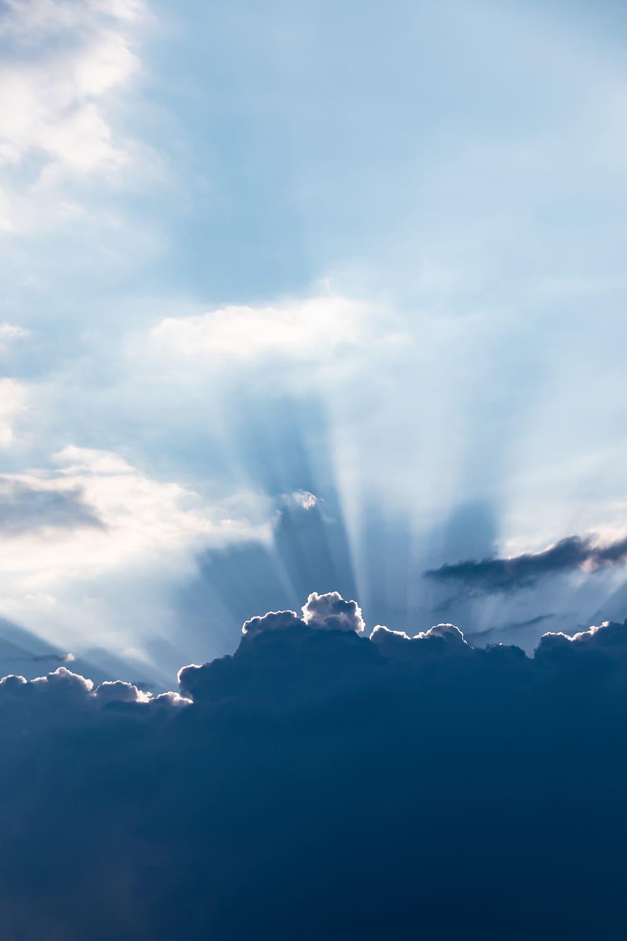 910x1365 HD wallpaper: sun rays above silhouette of clouds, sky, sunshine, light, blue
