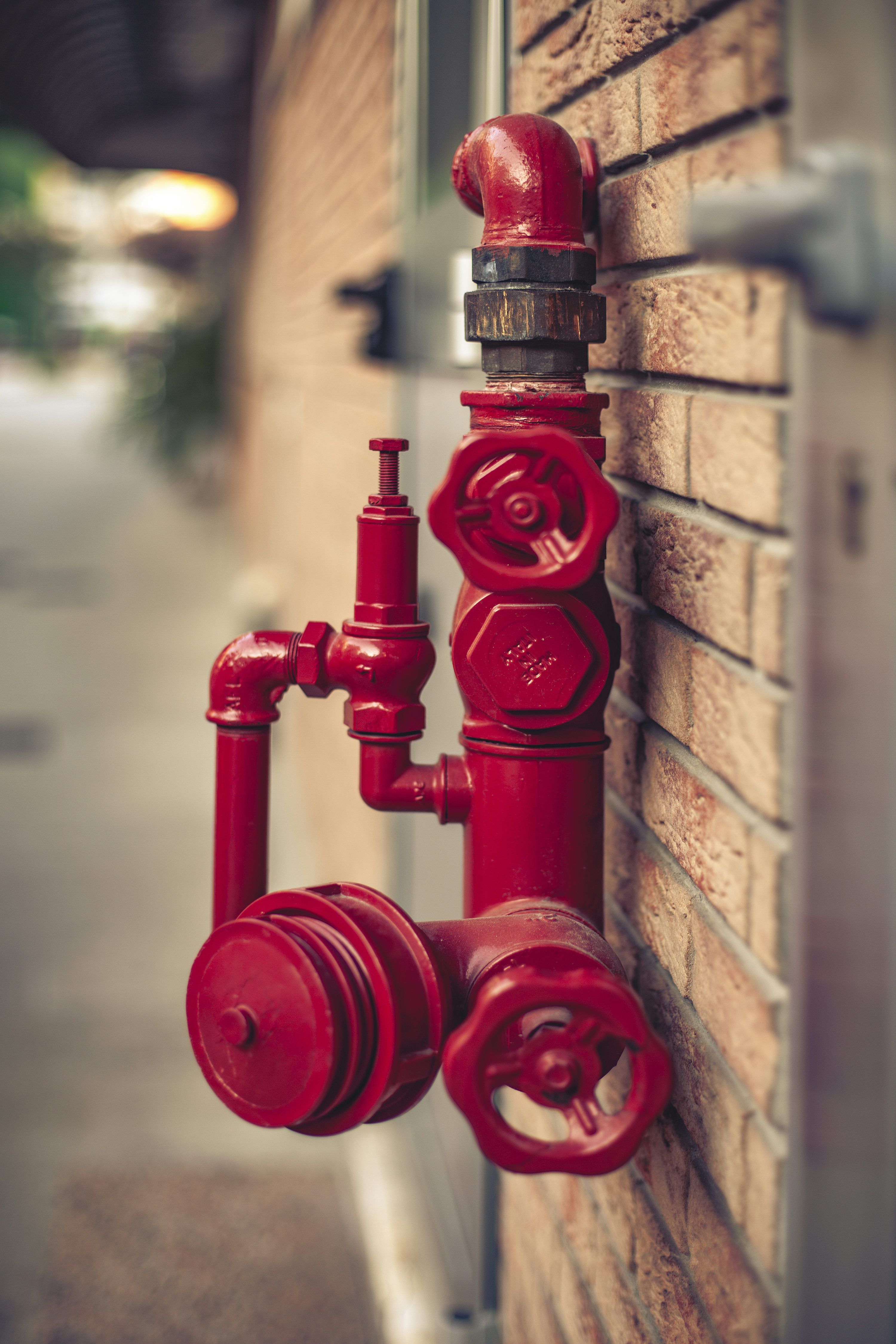 3000x4500 A red fire hydrant attached to a brick wall photo