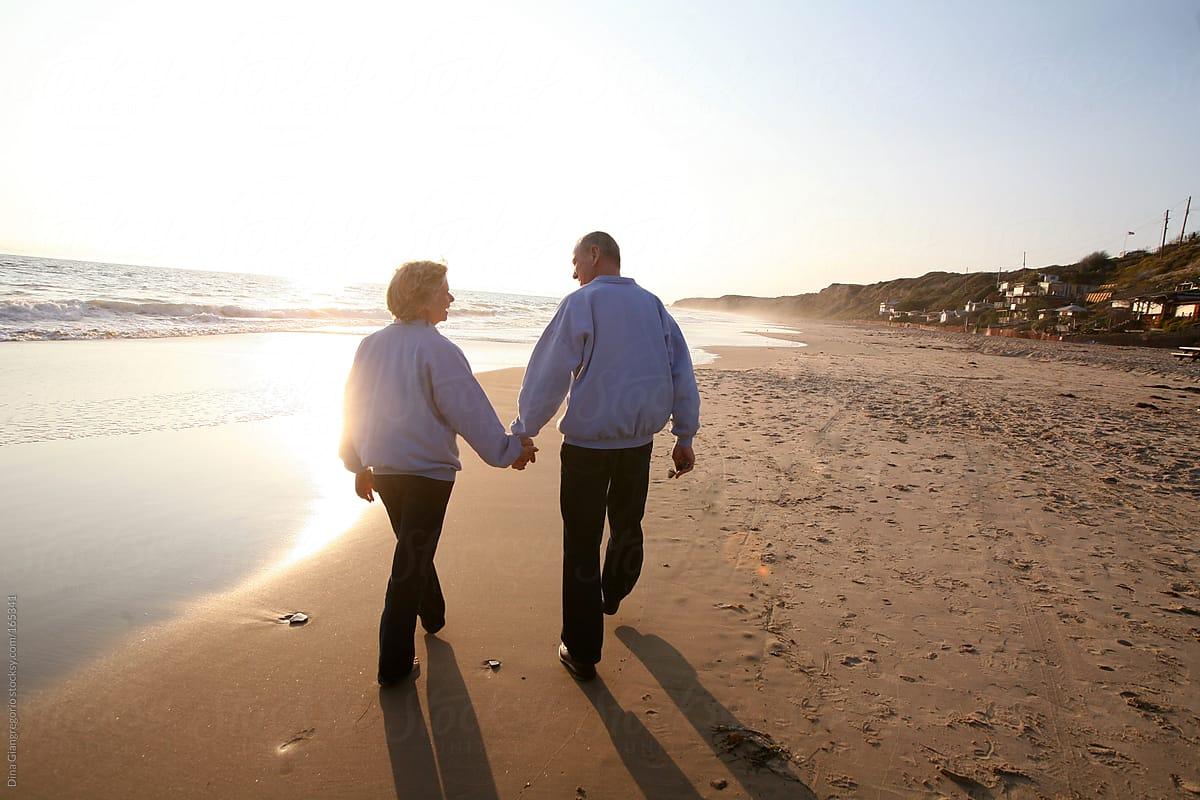 1200x800 Cặp vợ chồng già nắm tay nhau đi dạo trên bãi biển