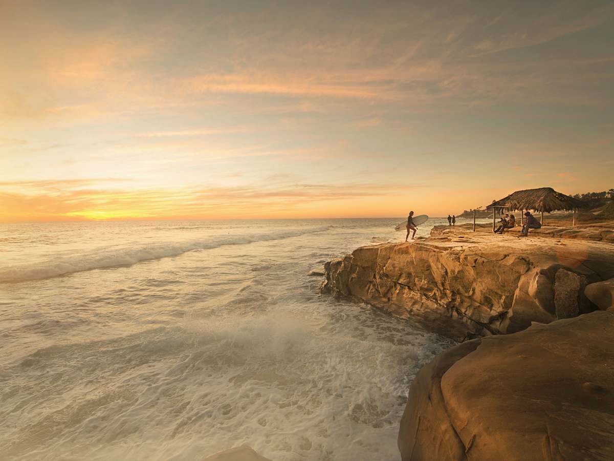 1200x900 san diego person holding surfboard near body of water beach