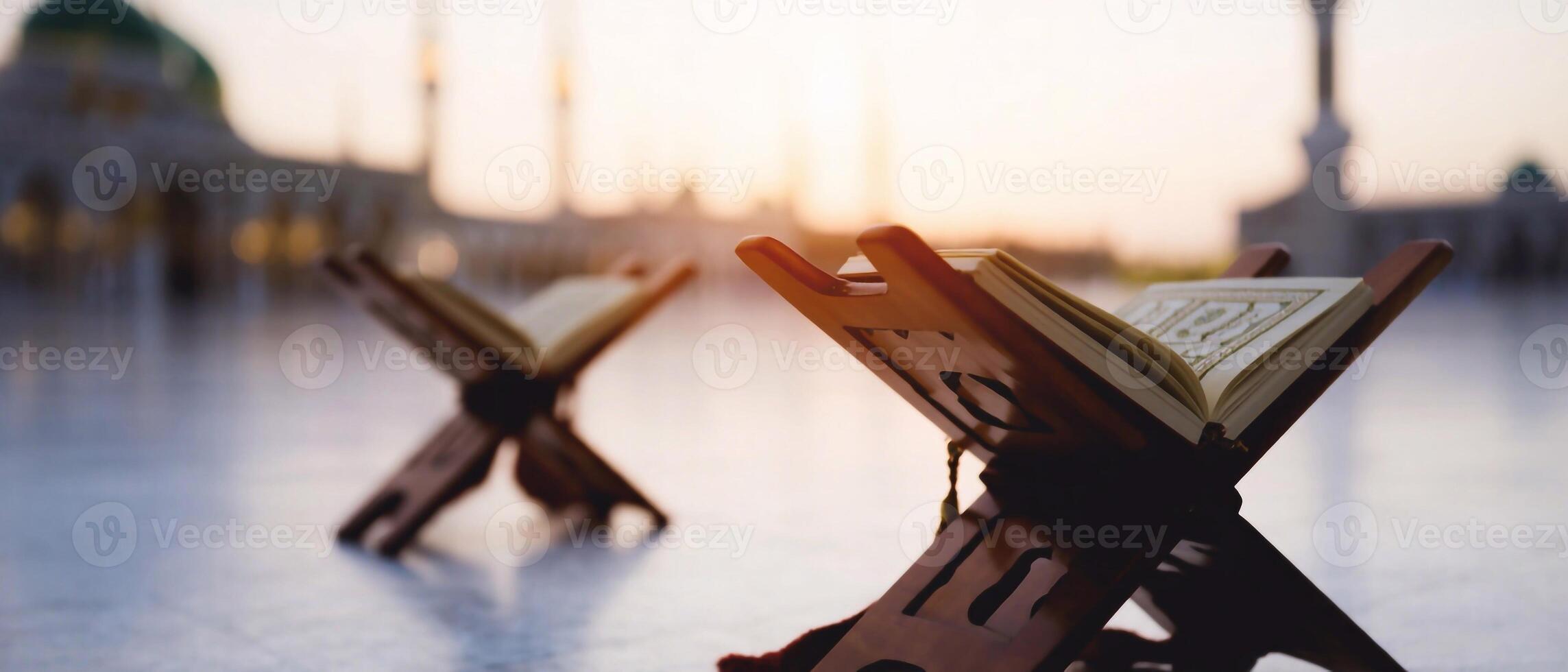 2287x980 Islamic holy book Quran placed on a wooden stand with a mosque in the background. Faith and devotion in Islam