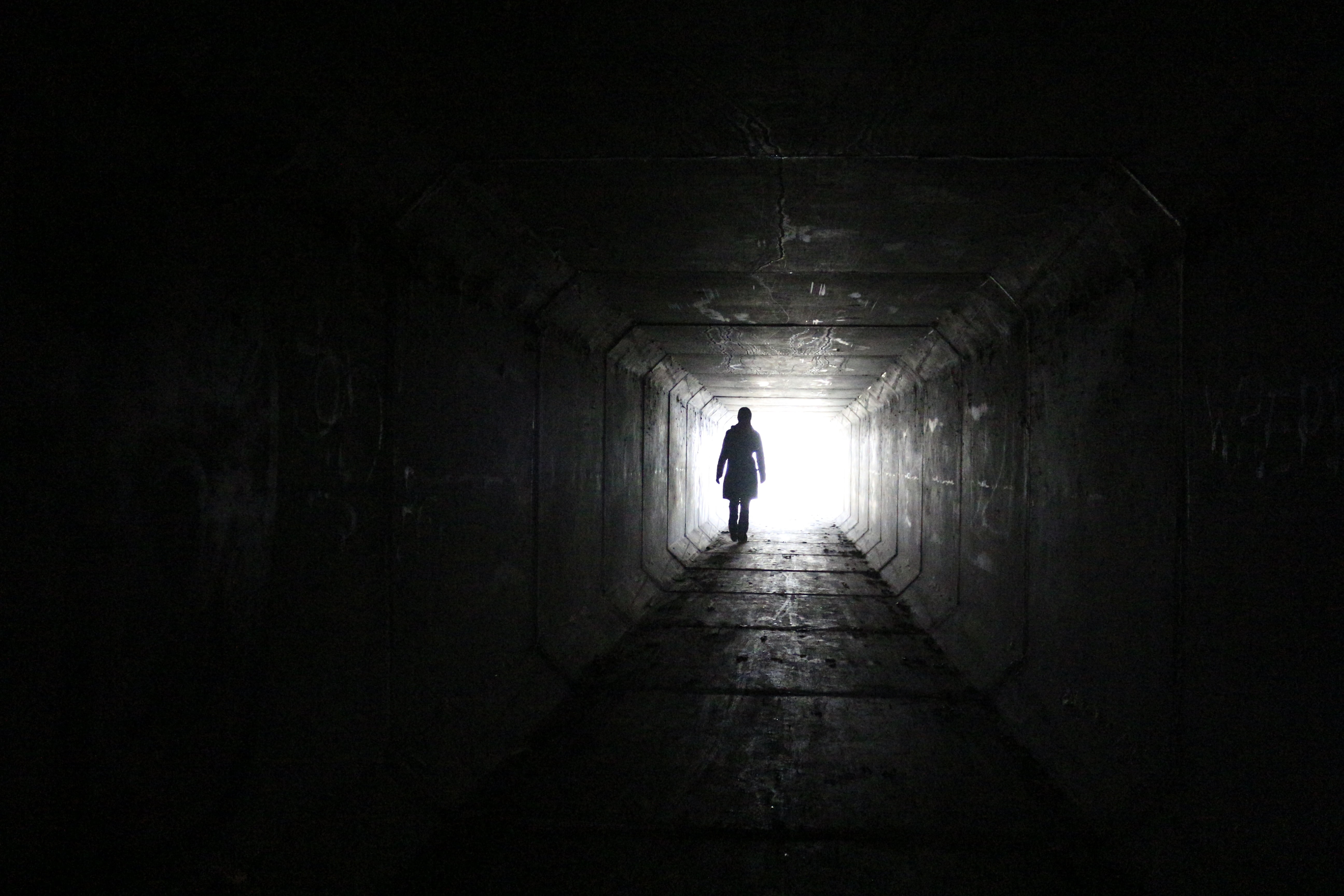 5184x3456 Person walking inside dark tunnel with white light on far distanc HD wallpaper