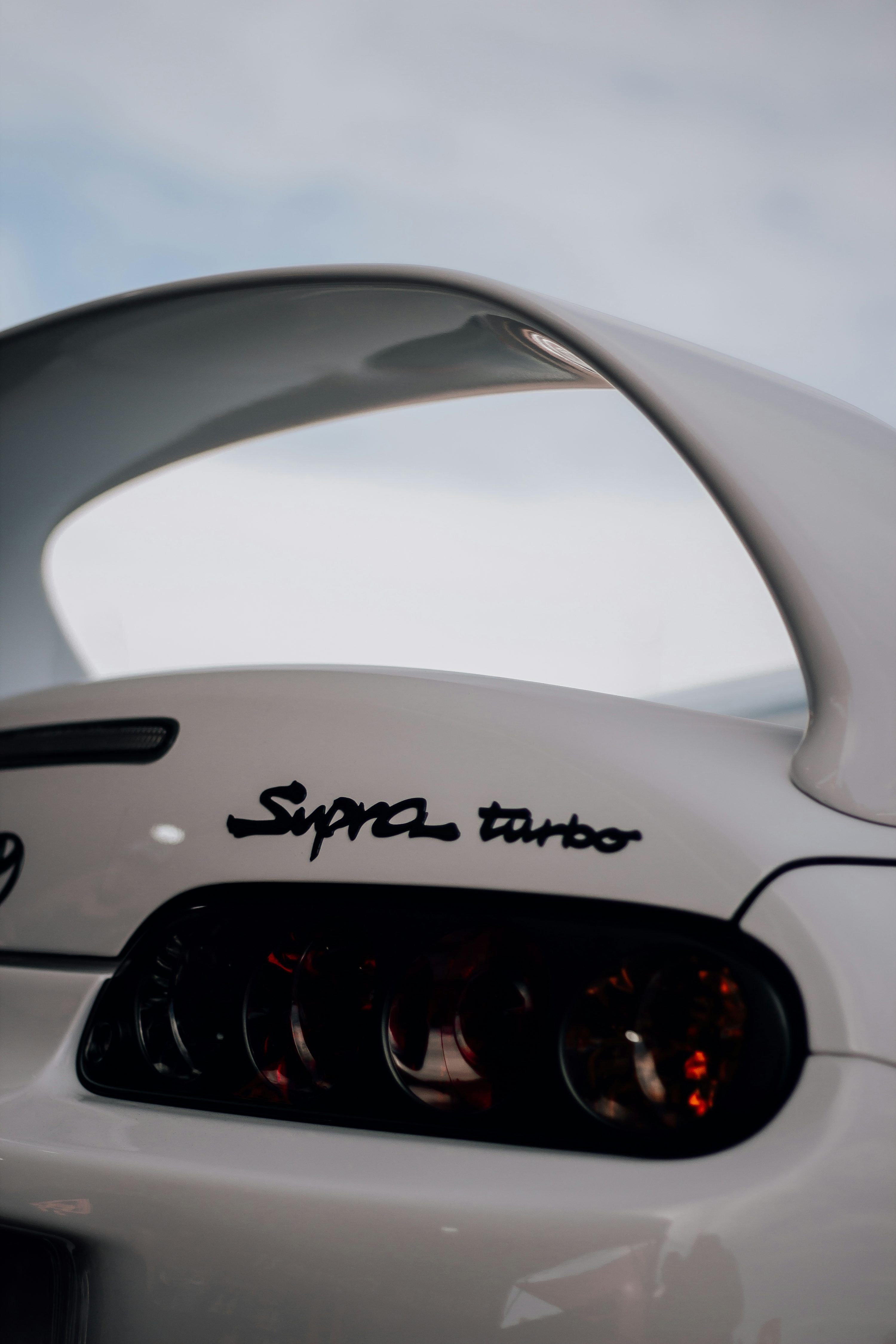 3000x4500 A close up of a white sports car with a sky background photo