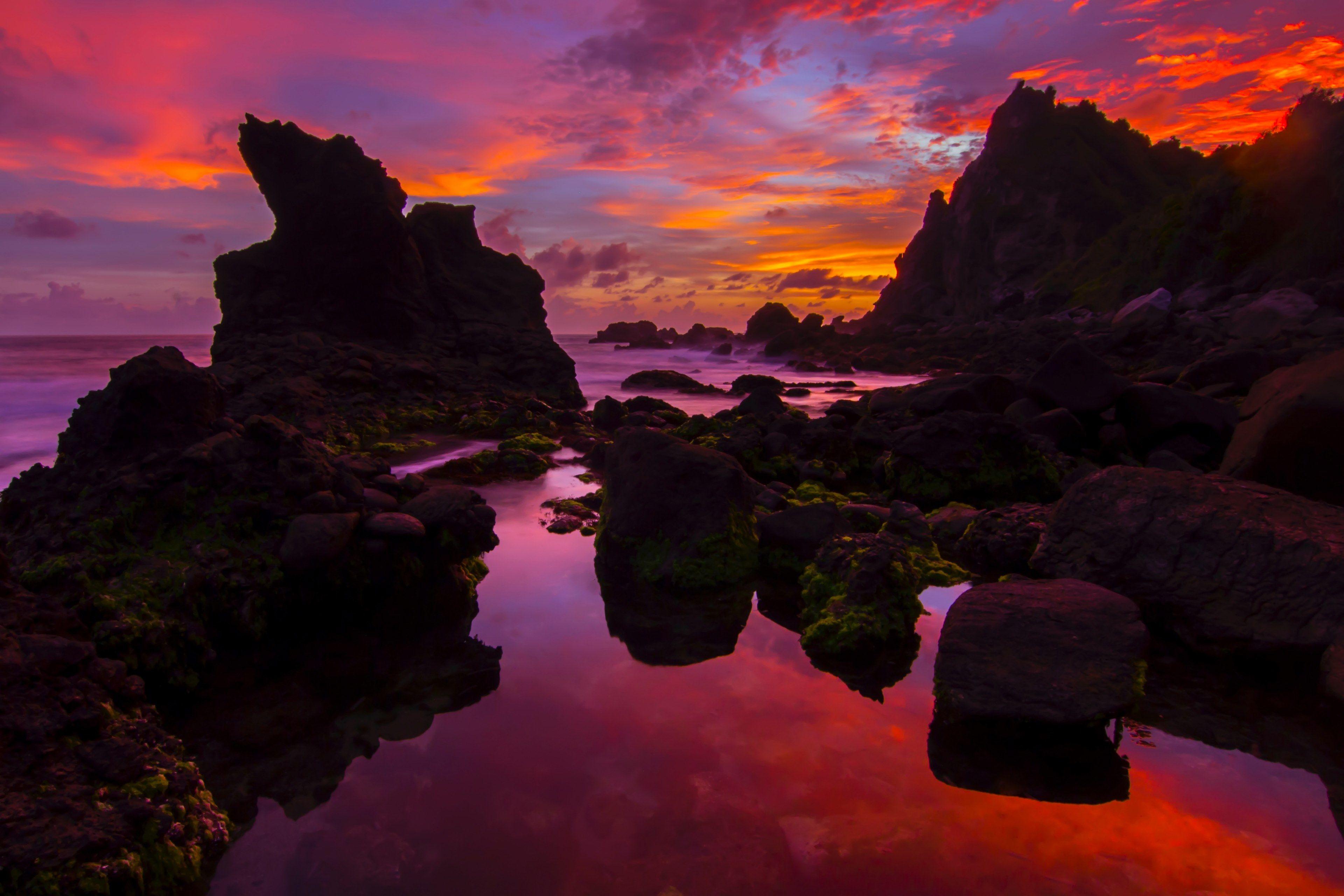 3840x2560 surreal pink and orange sunset over rock formations on the ocean