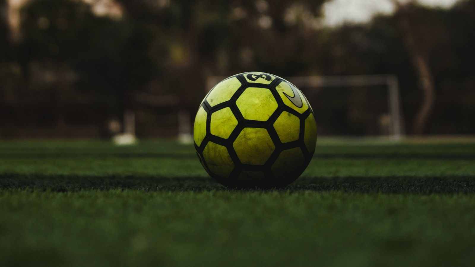 1600x900 Green Black Football On Grass In Blur Background HD Football Wallpaper