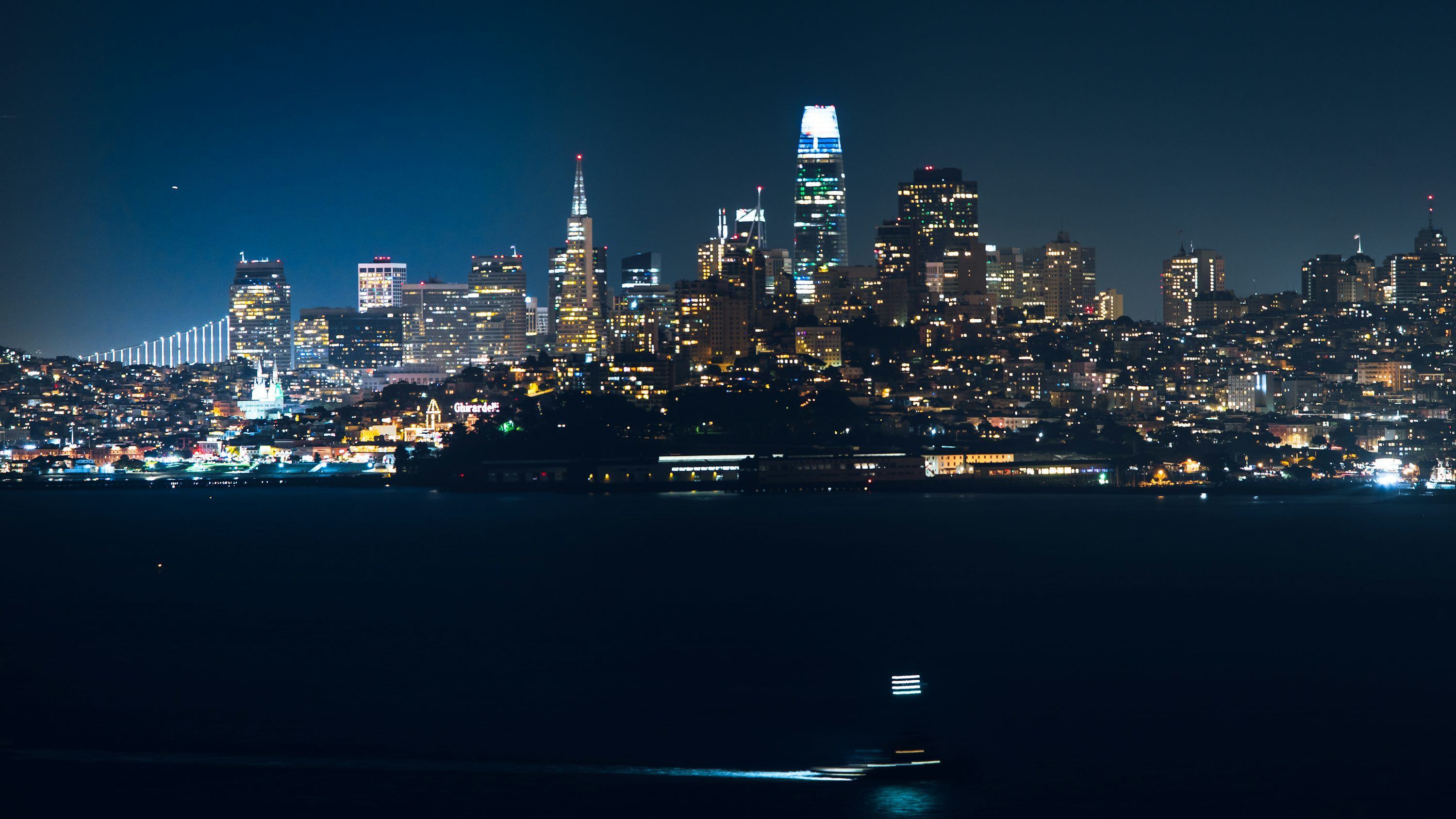3000x1688 A view of a city at night from across the water photo