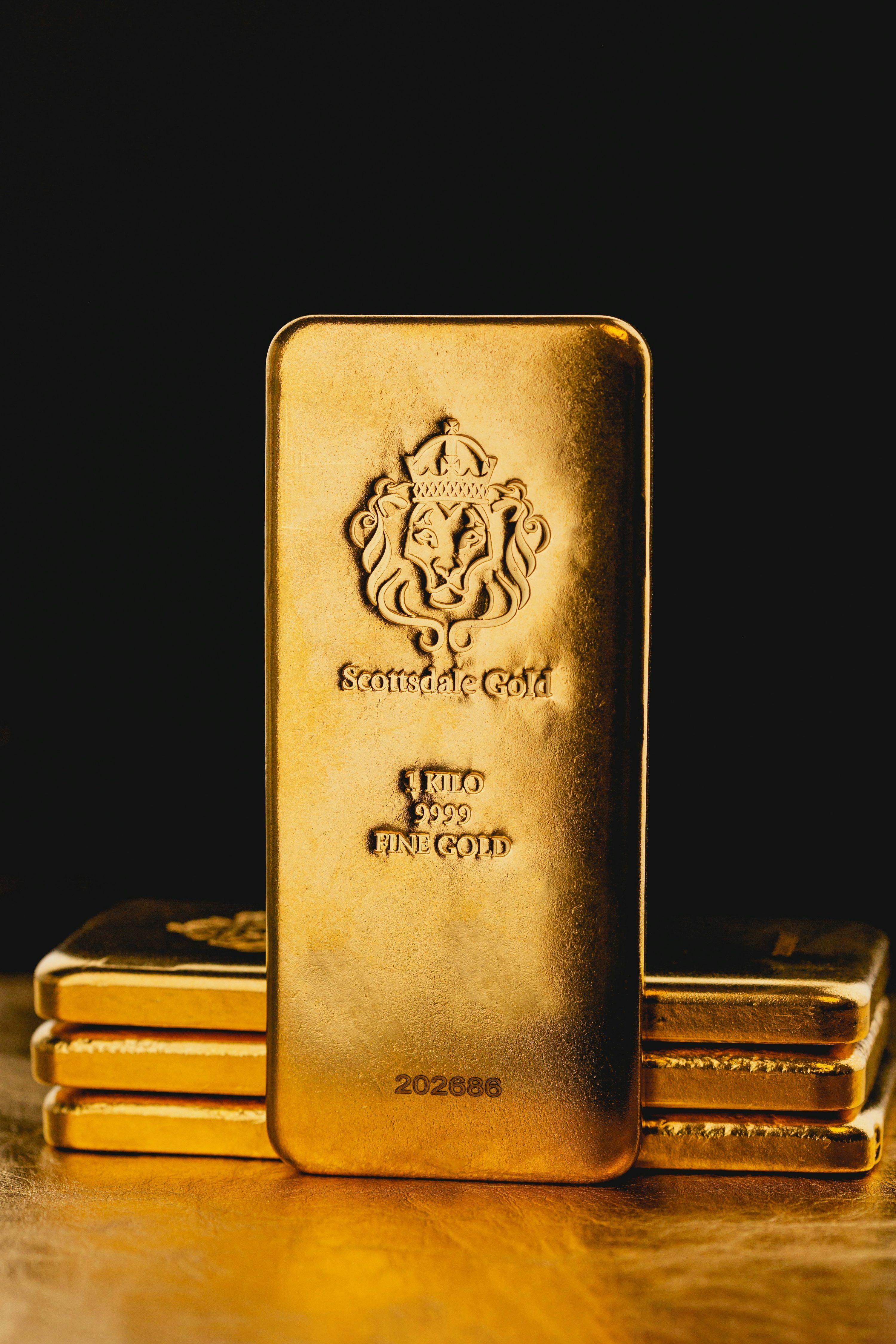 3000x4500 A stack of gold bars sitting on top of a wooden table photo