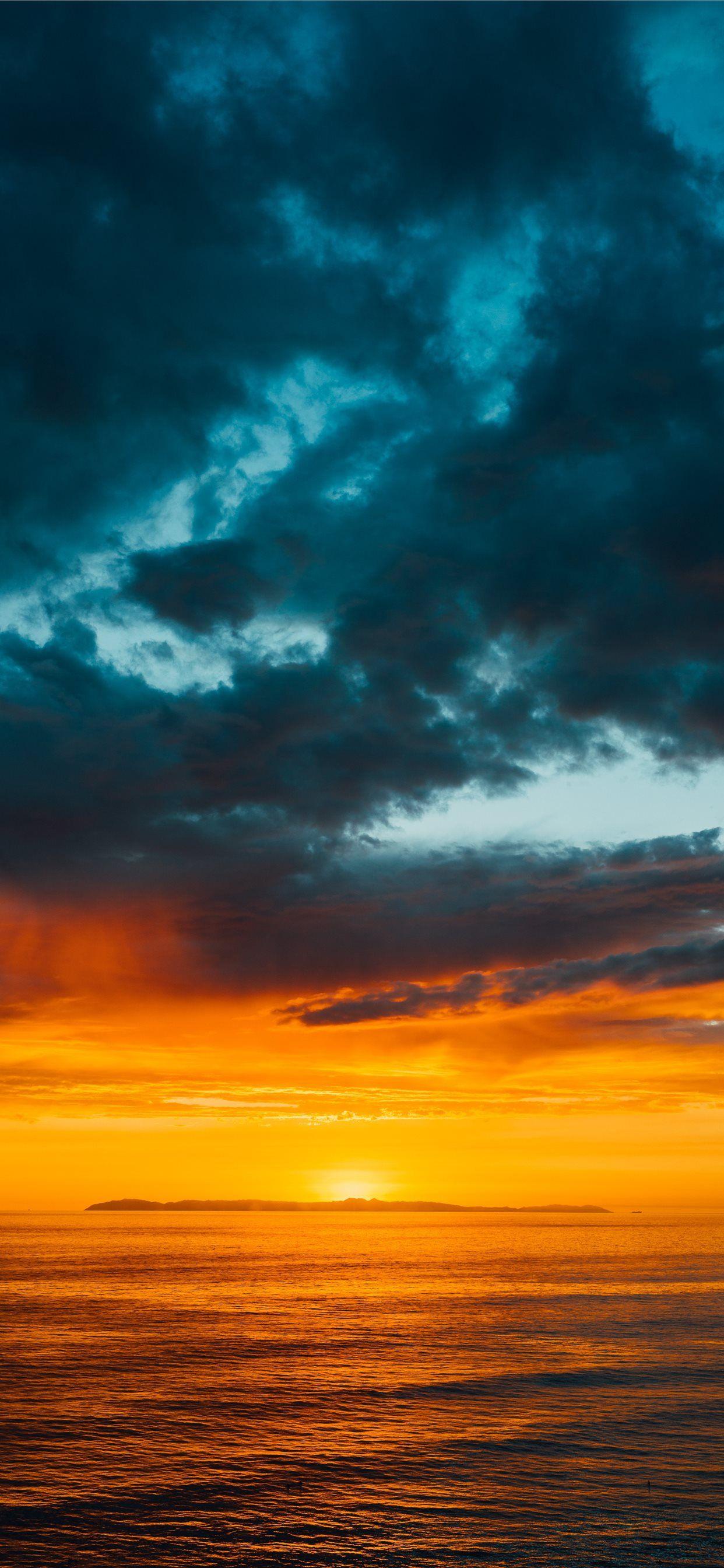 1242x2688 green and black clouds partly covering orange sky. iPhone X Wallpaper Free Download