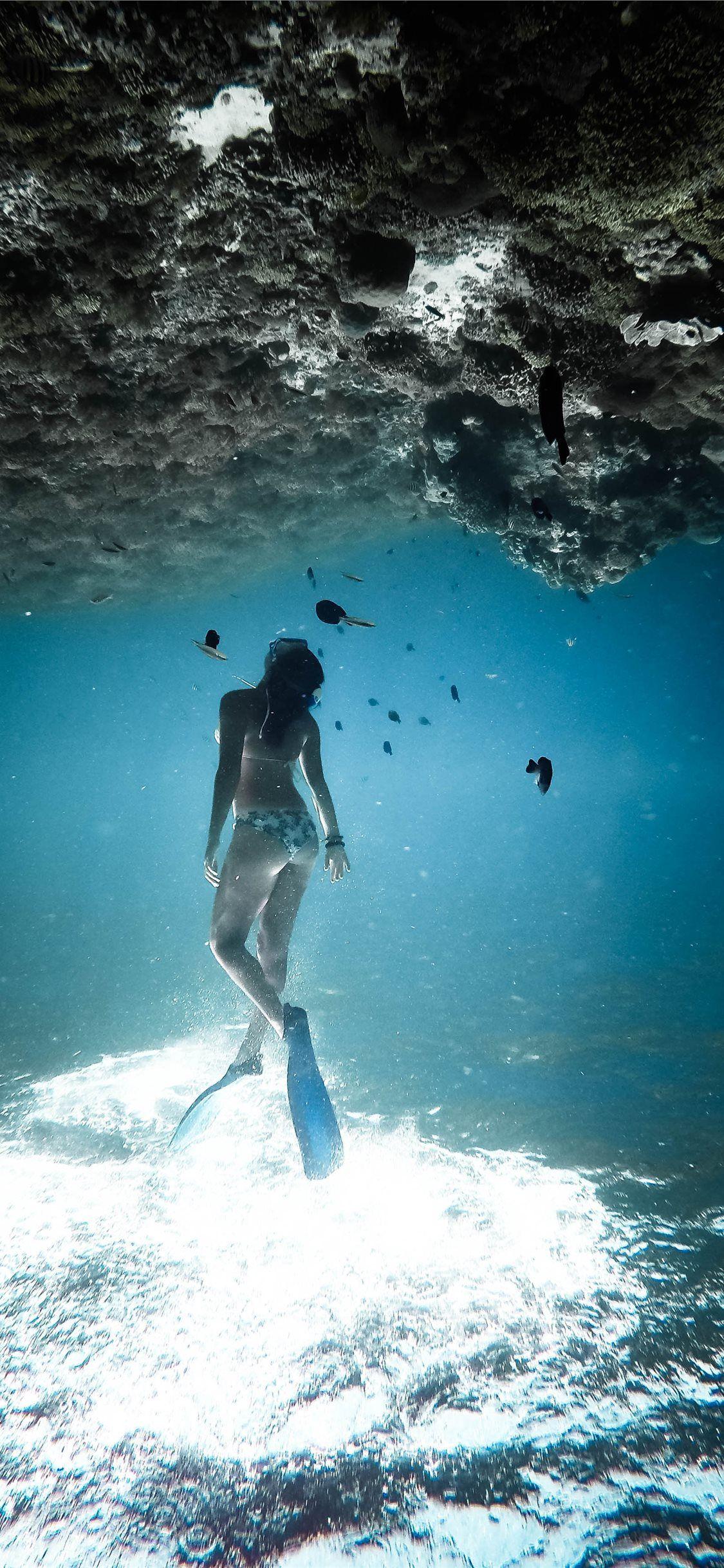 1125x2436 woman underwater wearing blue flippers iPhone X Wallpaper Free