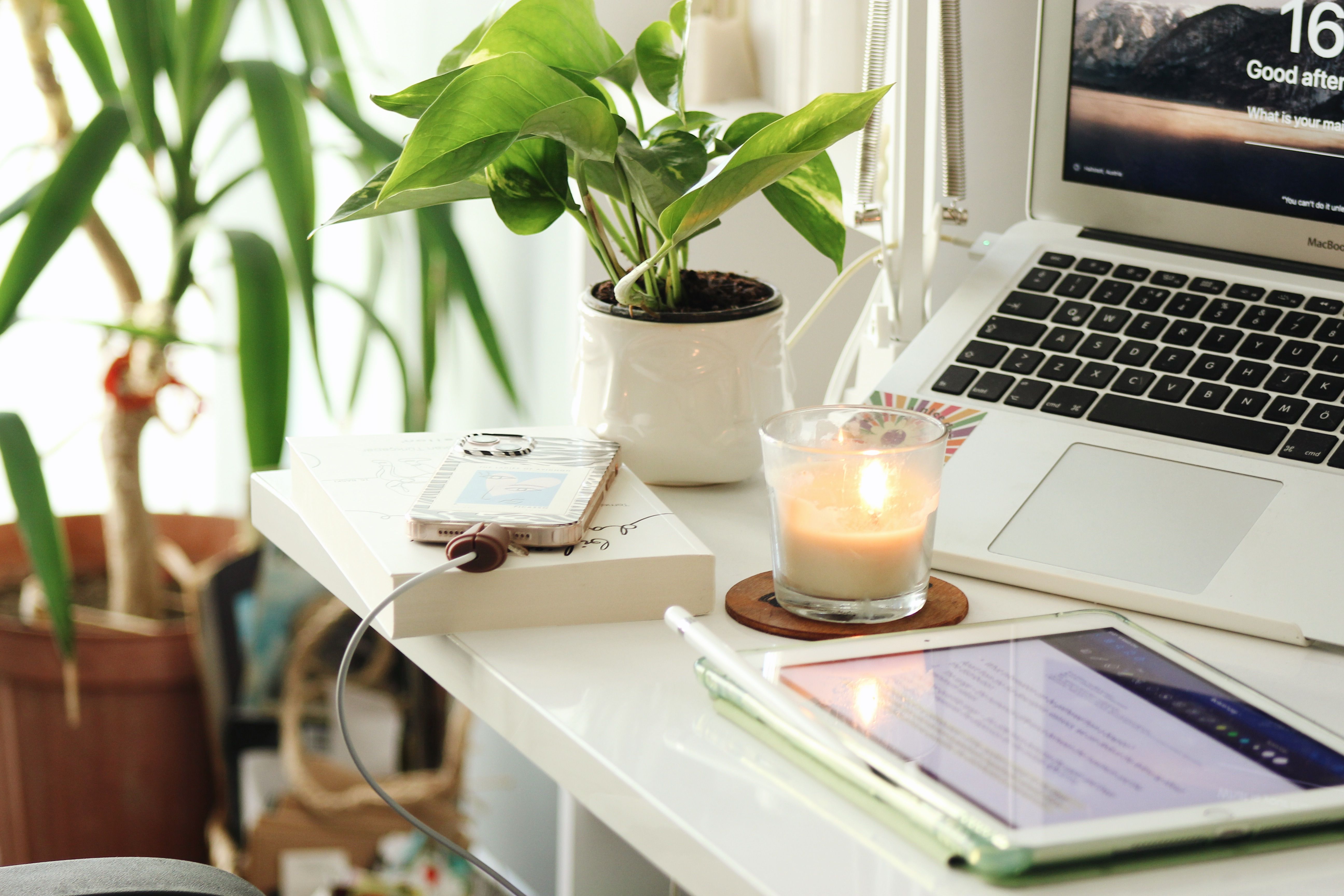 5184x3456 Work Space with Candle and Charging Phone on Desk · Free