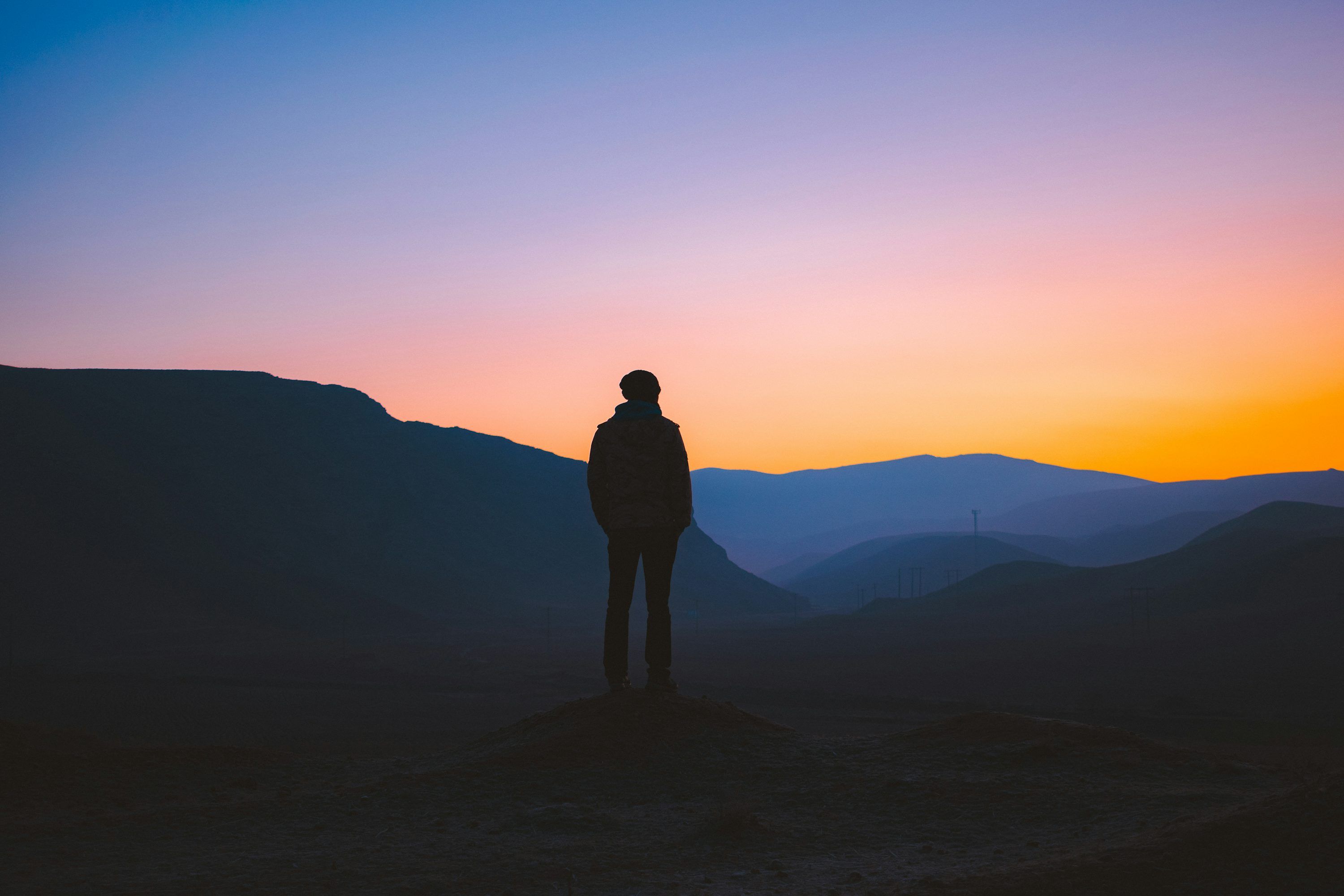 3000x2000 Silhouette of man standing on mountain during sunset photo