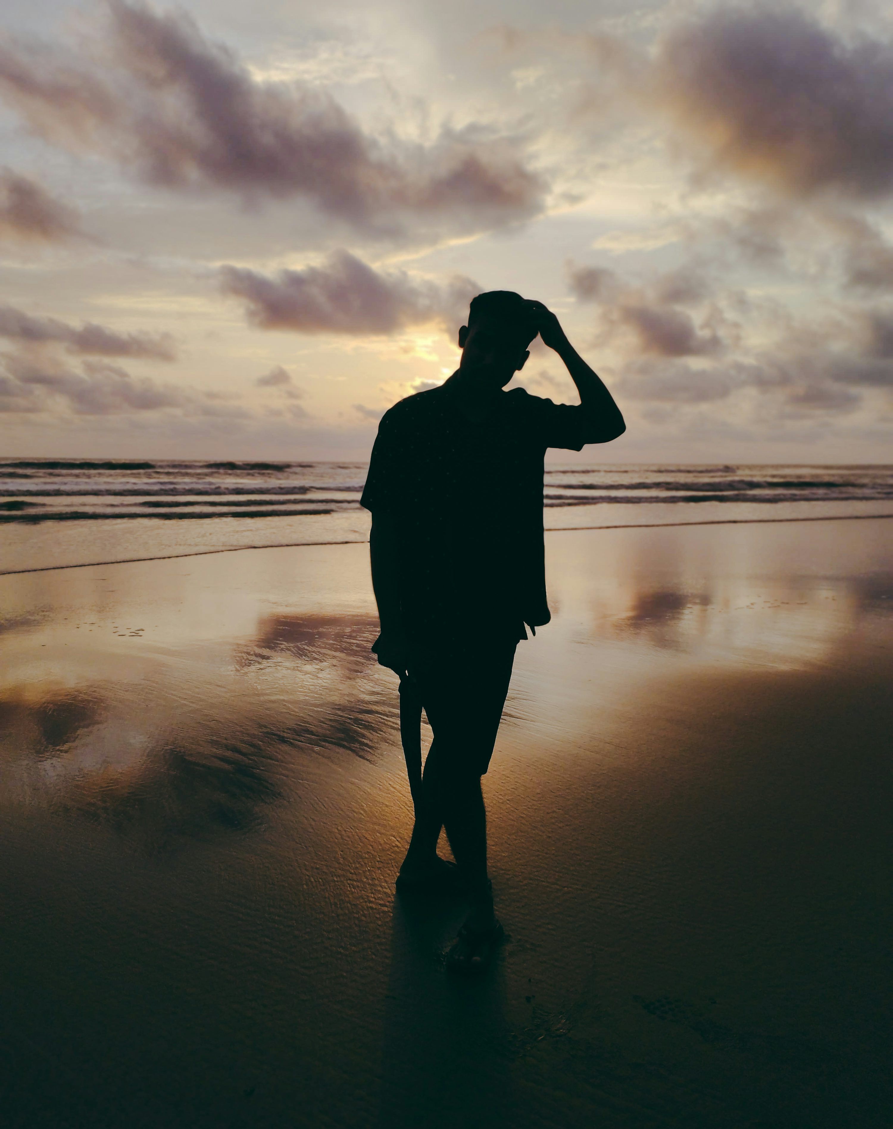 3000x3795 Man silhouetted on a beach at sunset. photo