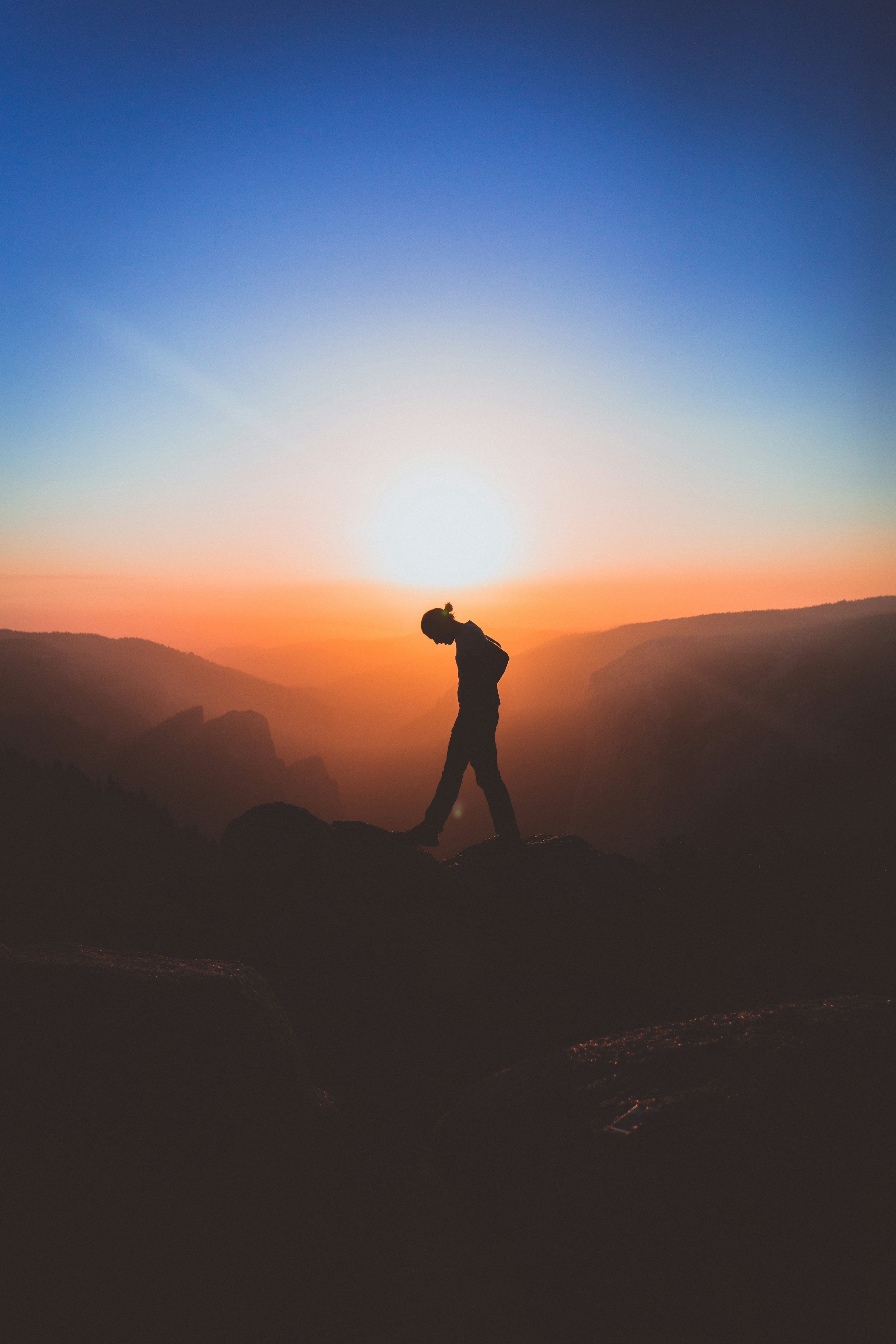 3000x4500 Silhouette of man standing on mountain peak photo