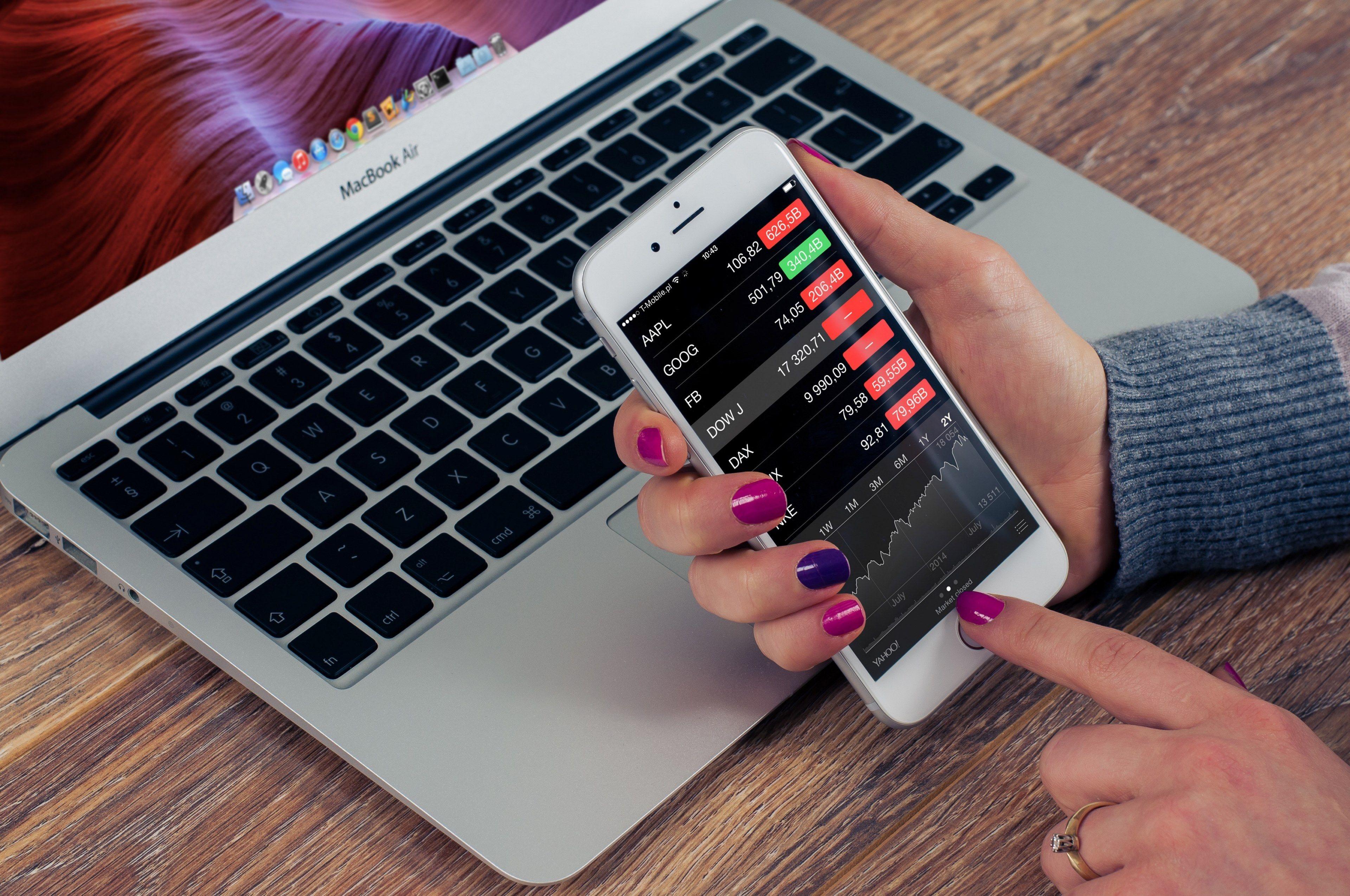 3840x2550 a person checking stock market prices on their iphonechecking