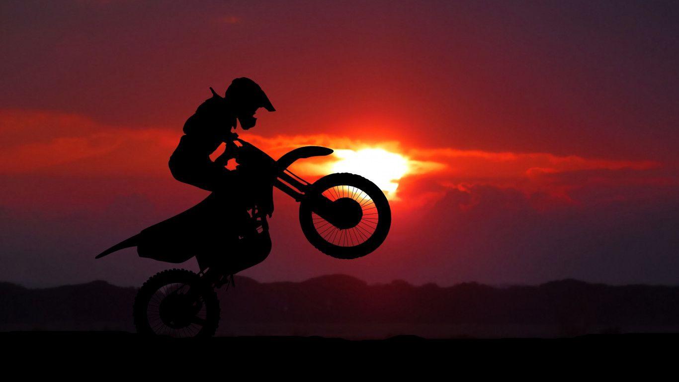 1366x768 Download wallpaper: Biker on motorcycle at sunrise 1366x768