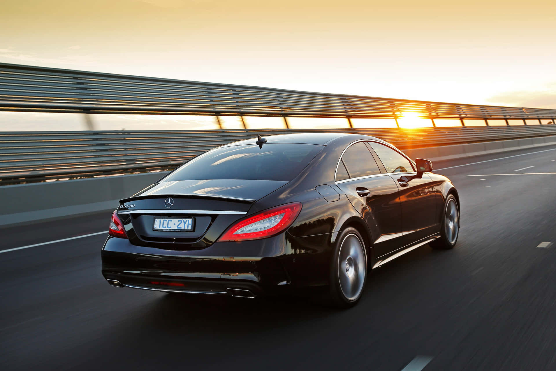 1920x1280 Download Stunning Mercedes Benz CLS Class In Motion On A Scenic Road Wallpaper