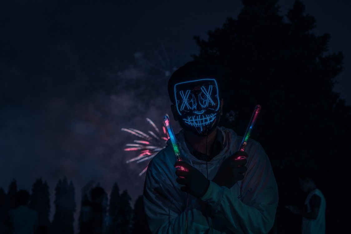 1125x750 A Man Wearing a Glow in the Dark Mask Holding Light Sticks · Free