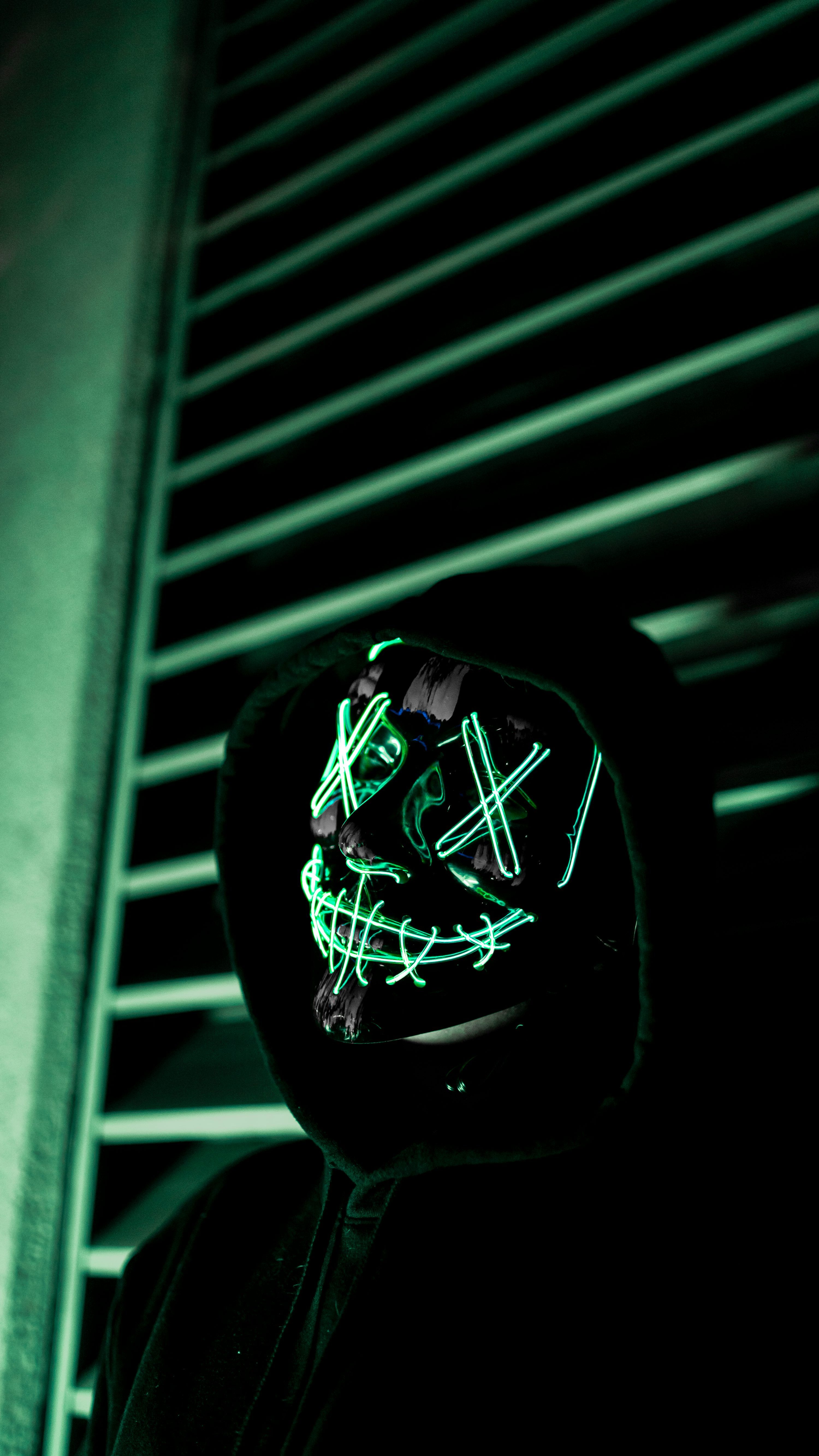 3000x5332 A person wearing a neon mask in the dark photo
