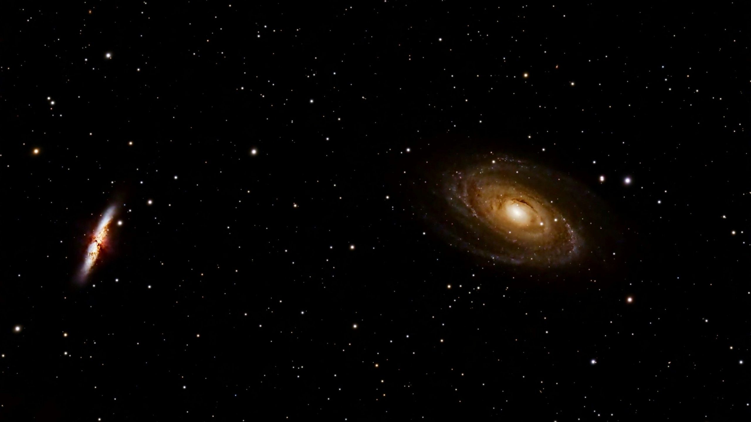 2560x1440 deep space image showing the bright spiral galaxy M81 and the starburst galaxy M82 against a backdrop of countless stars 4K HD space Wallpaper