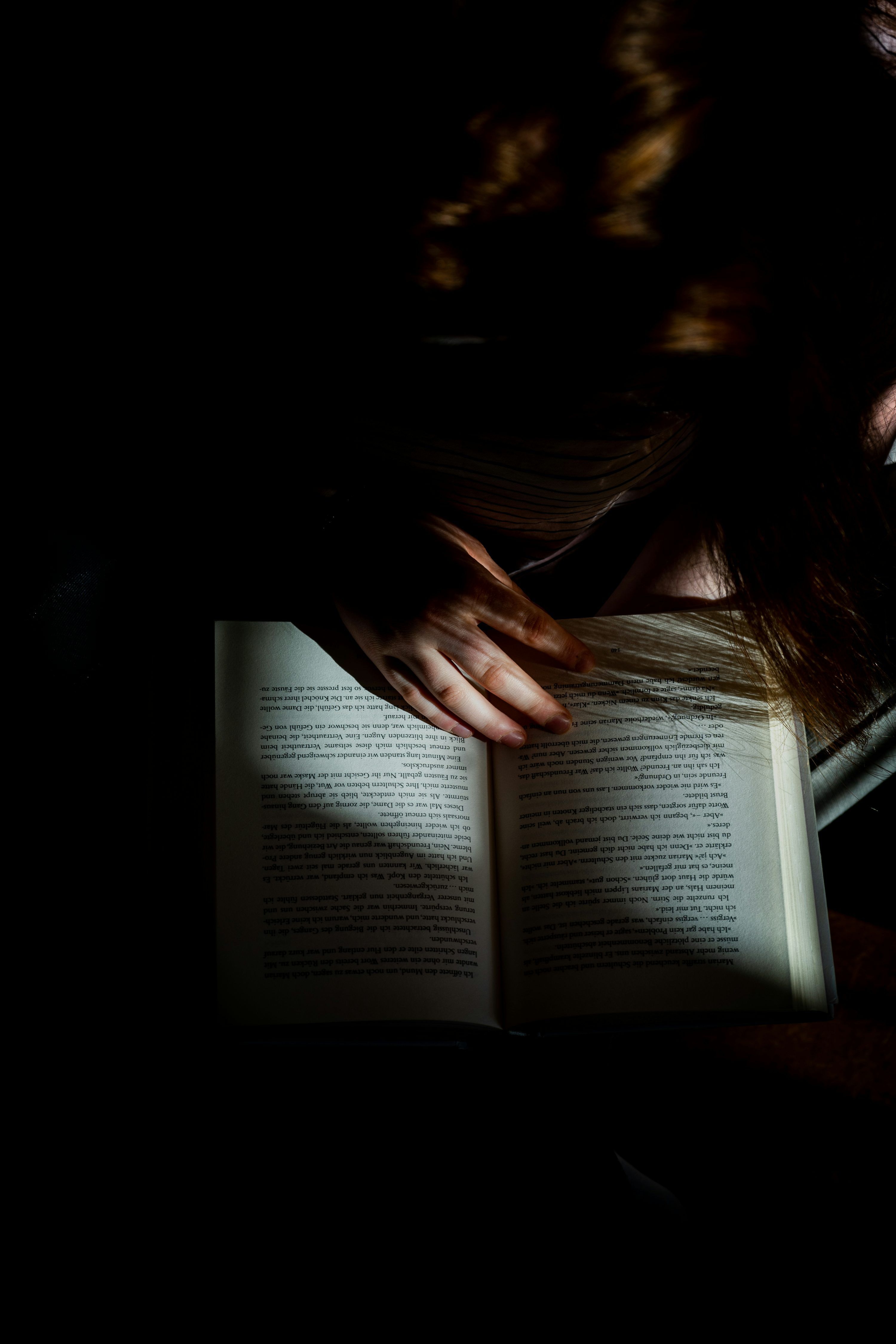 3000x4500 Woman reading book on brown wooden table photo