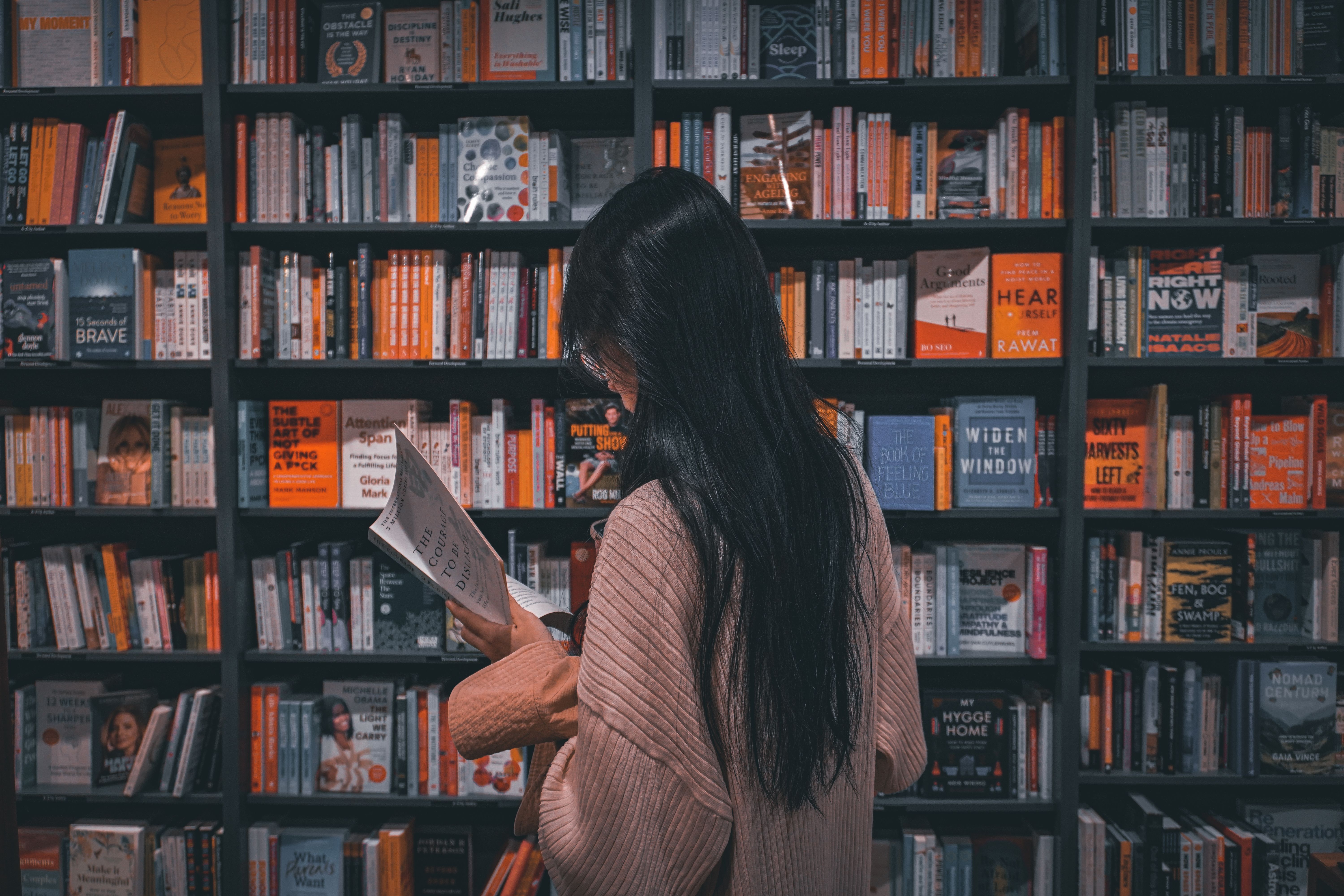 6000x4000 Lady Reading a Book in a Library · Free