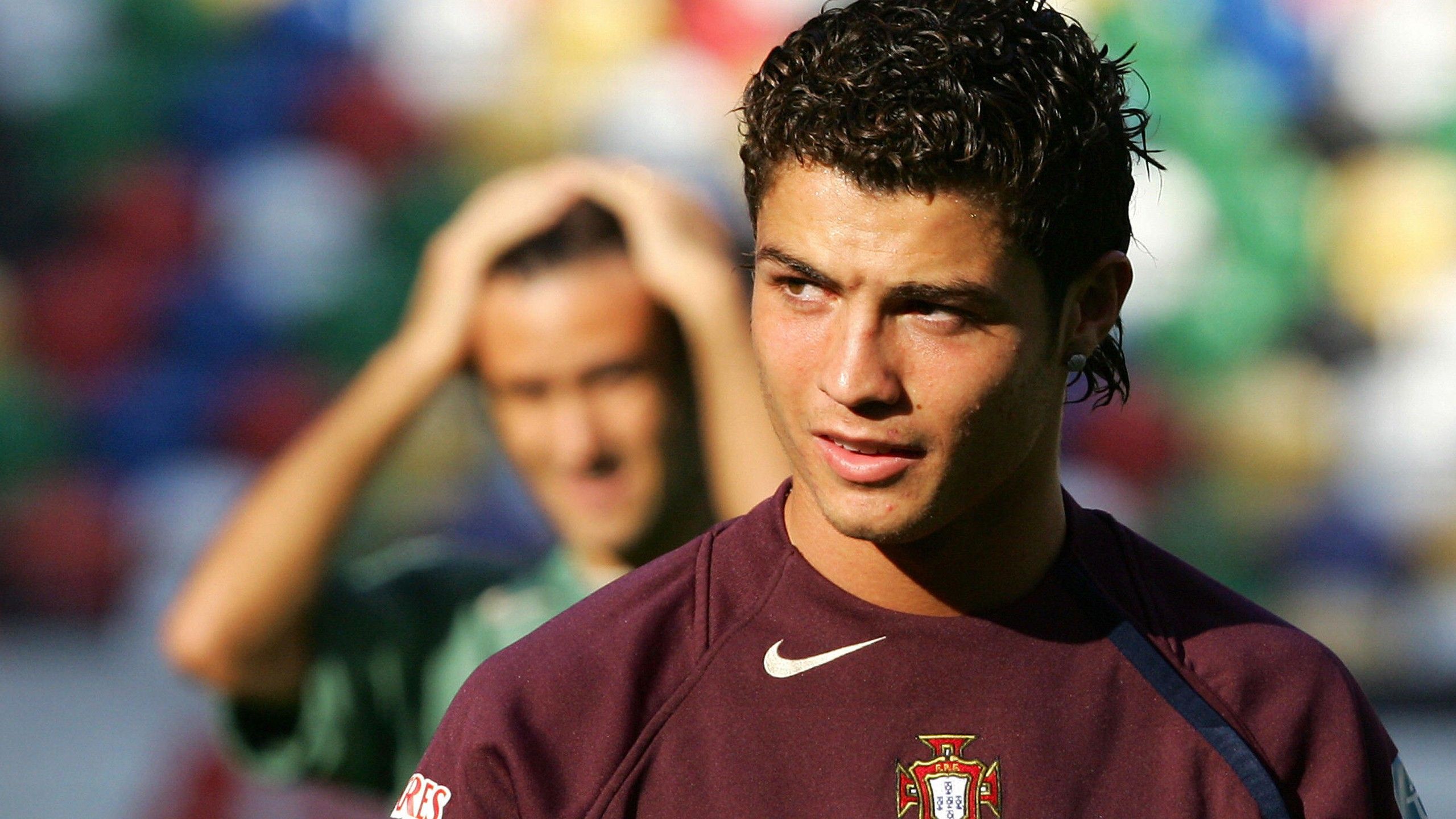 2560x1440 Young Cristiano Ronaldo Is Wearing Dark Maroon Sports Dress Standing In Colorful Blur Background HD Ronaldo Wallpaper