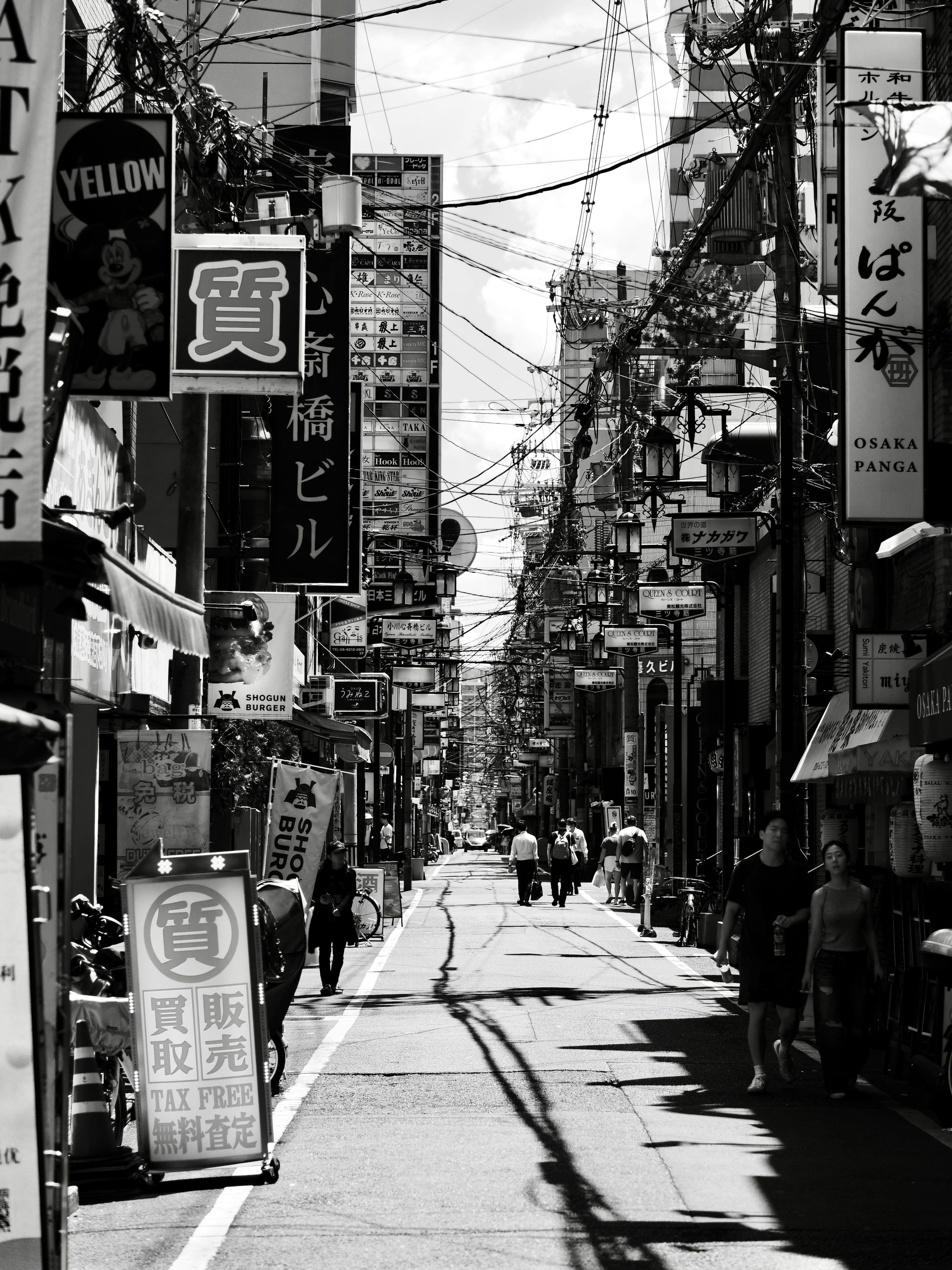 3000x4000 A narrow street in japan with signs and people. photo
